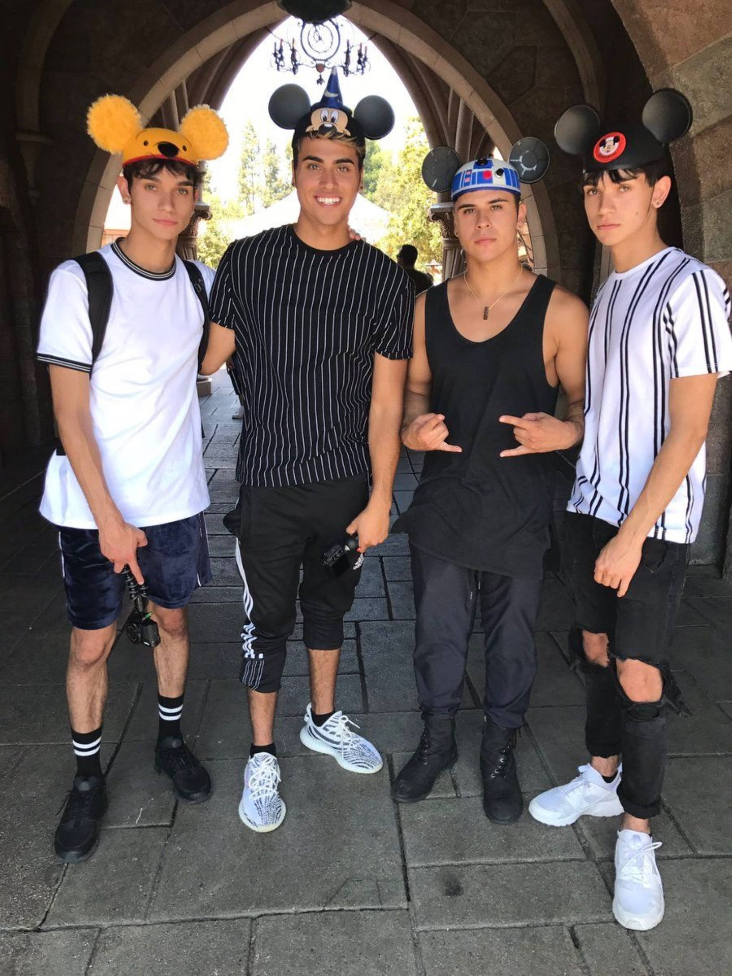 Dobre 桌布 壁紙 — 四個年輕男子戴著米奇老鼠耳朵，在主題公園的石拱門下愉快地擺姿勢。