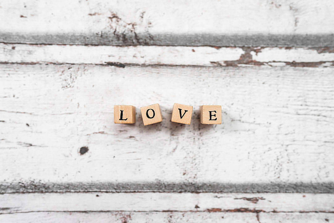 I Love You Aesthetic 桌布 壁紙 — 四個拼出 LOVE 的木塊放置在一個油漆剝落、風化的白色木質表面上。