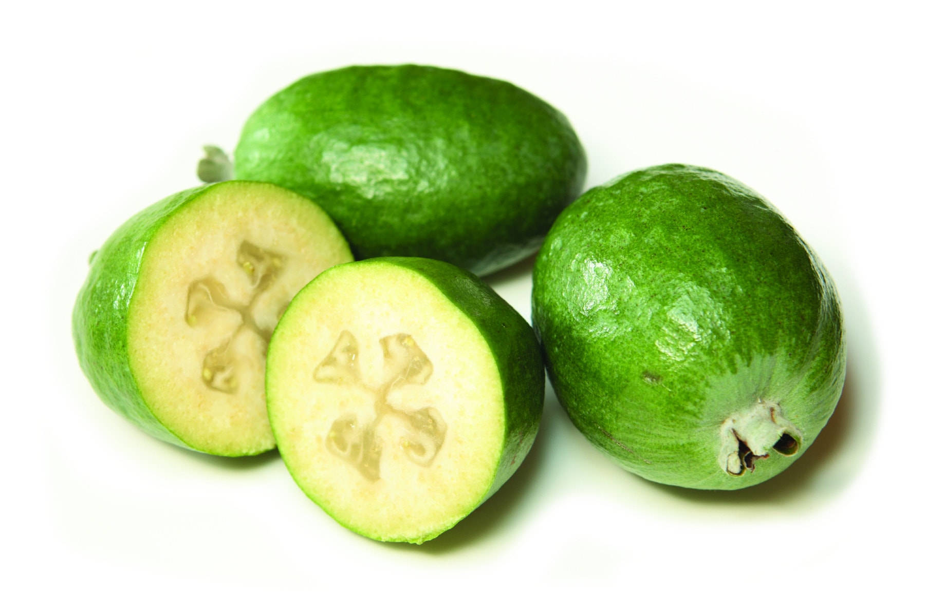 Fruit 桌布 壁紙 — 四個新鮮的綠色菲油果，其中兩個切開露出星形種子，背景為潔白。