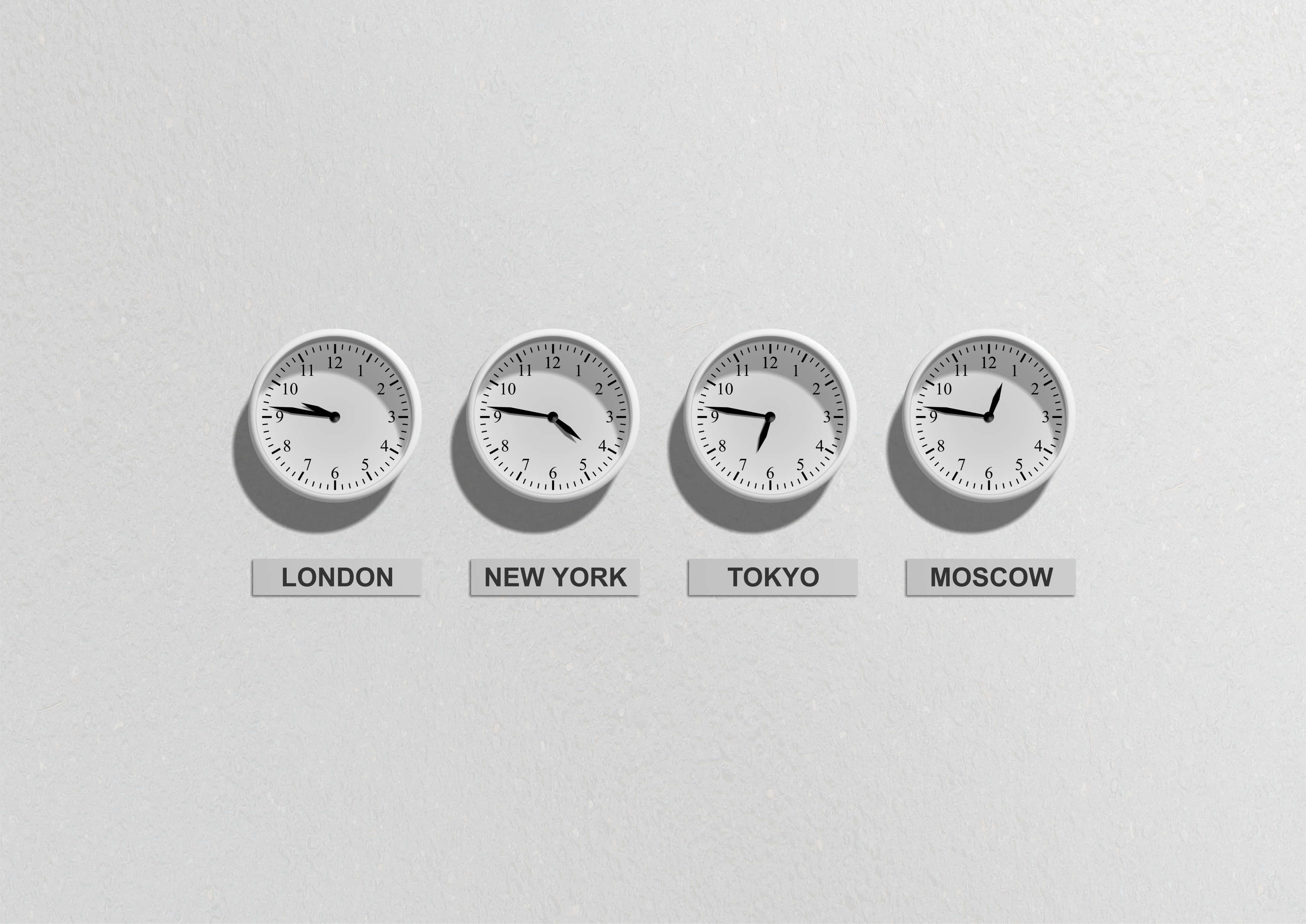 Clock 桌布 壁紙 — 四個極簡主義的指針時鐘，標有倫敦、紐約、東京、莫斯科，在素牆上顯示不同時間。