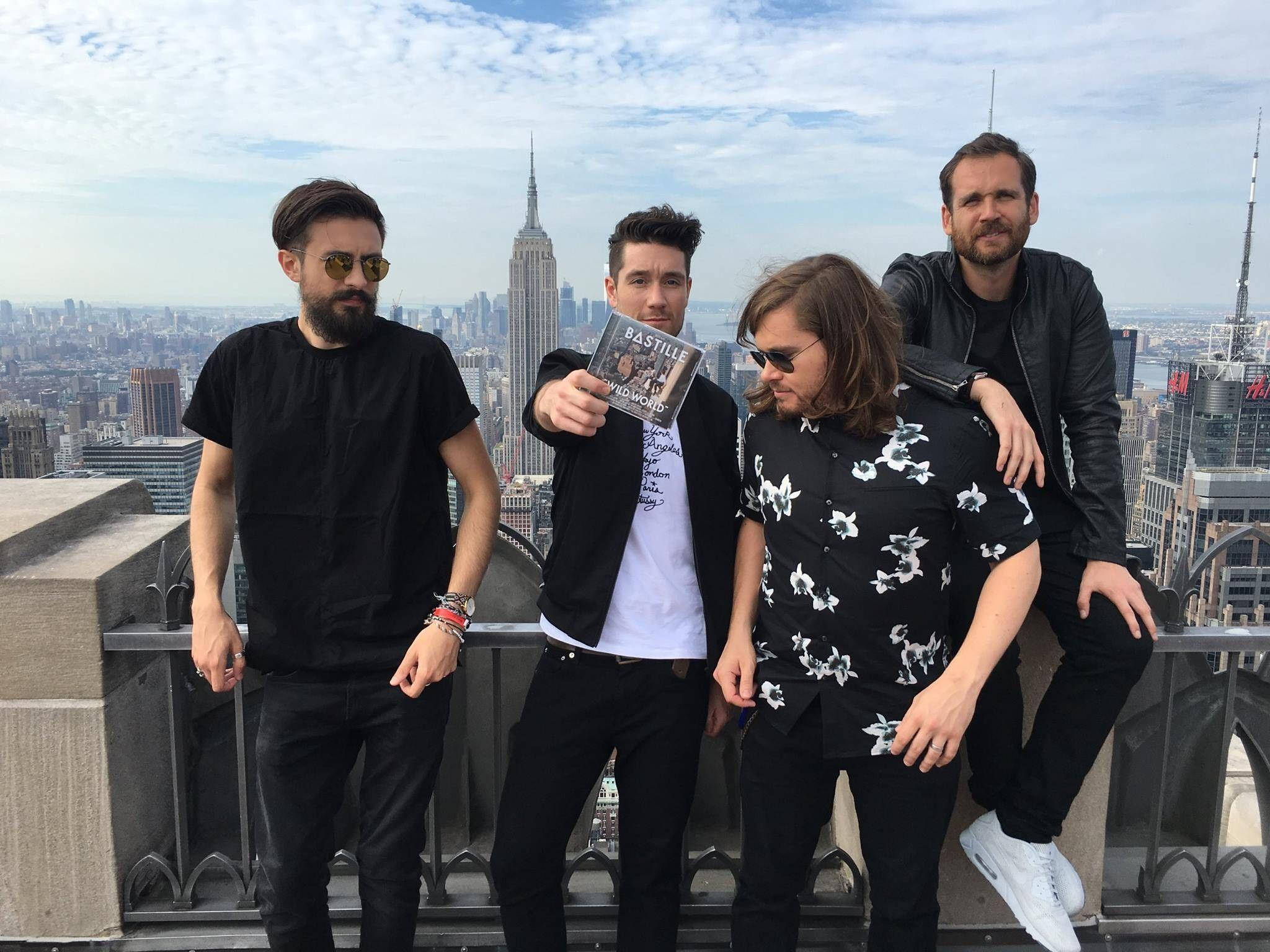 Bastille 桌布 壁紙 — 四個男人在一個屋頂上擺姿勢，俯瞰紐約市，背景是帝國大廈。