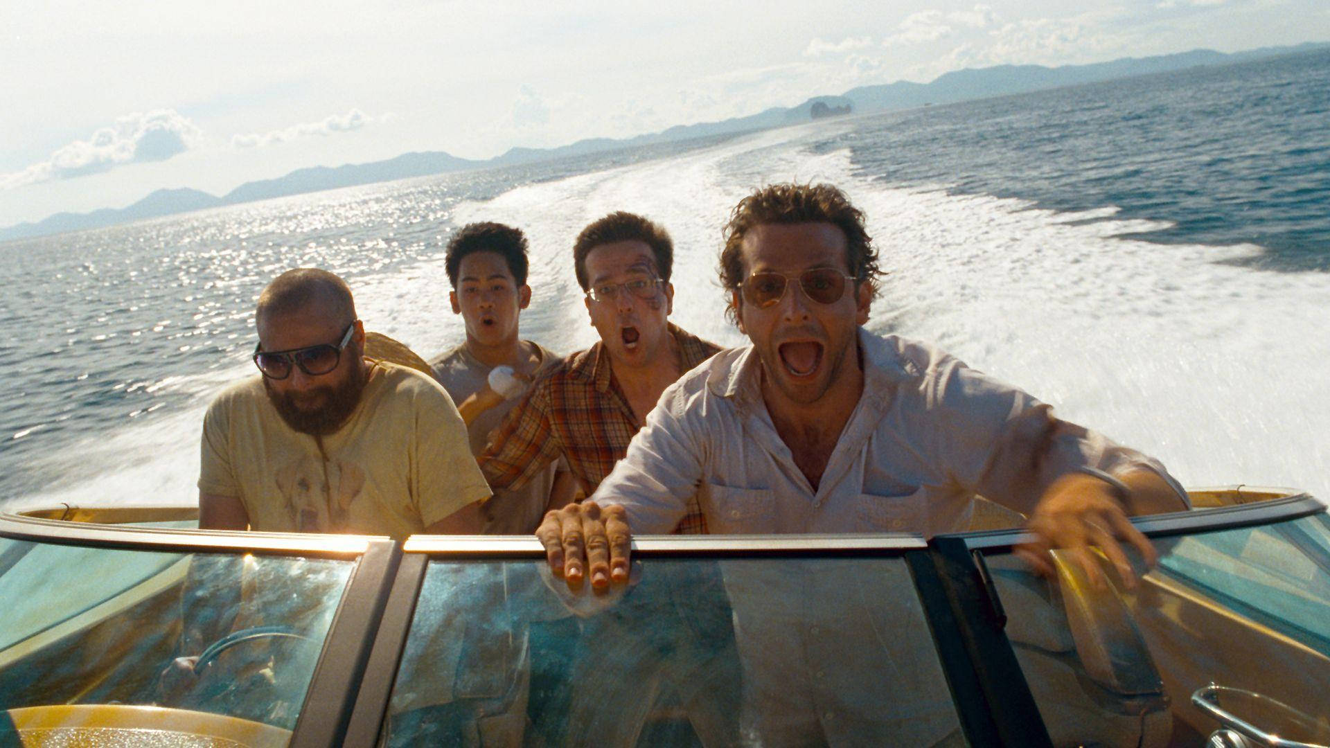 the hangover 桌布 壁紙 — 四個男人在一艘高速快艇上，在燦爛陽光下，在閃閃發光的海面上興奮咆哮。