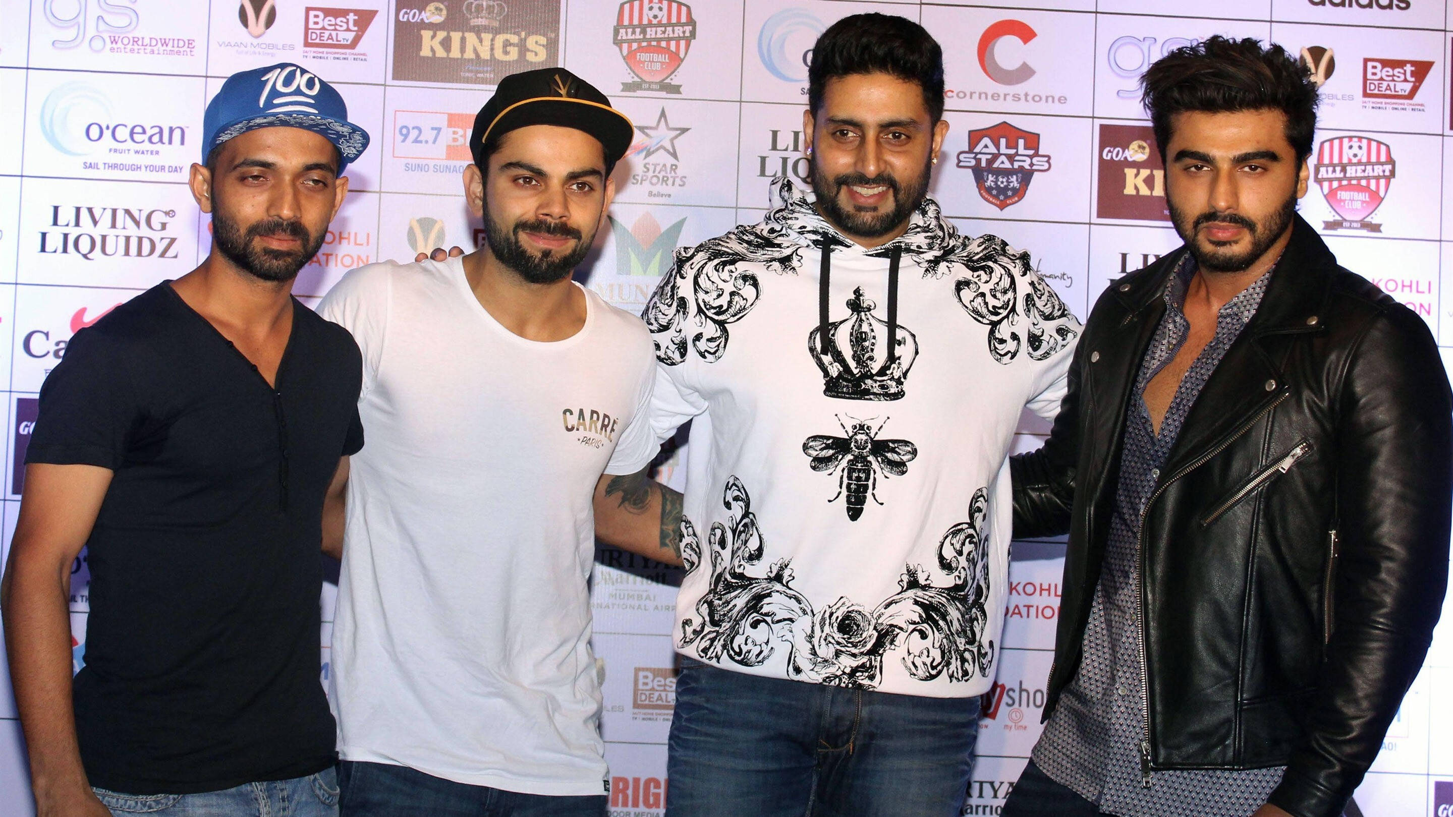abhishek bachchan 桌布 壁紙 — 四個男人在帶有標誌和文字的活動背景前自信地擺姿勢。
