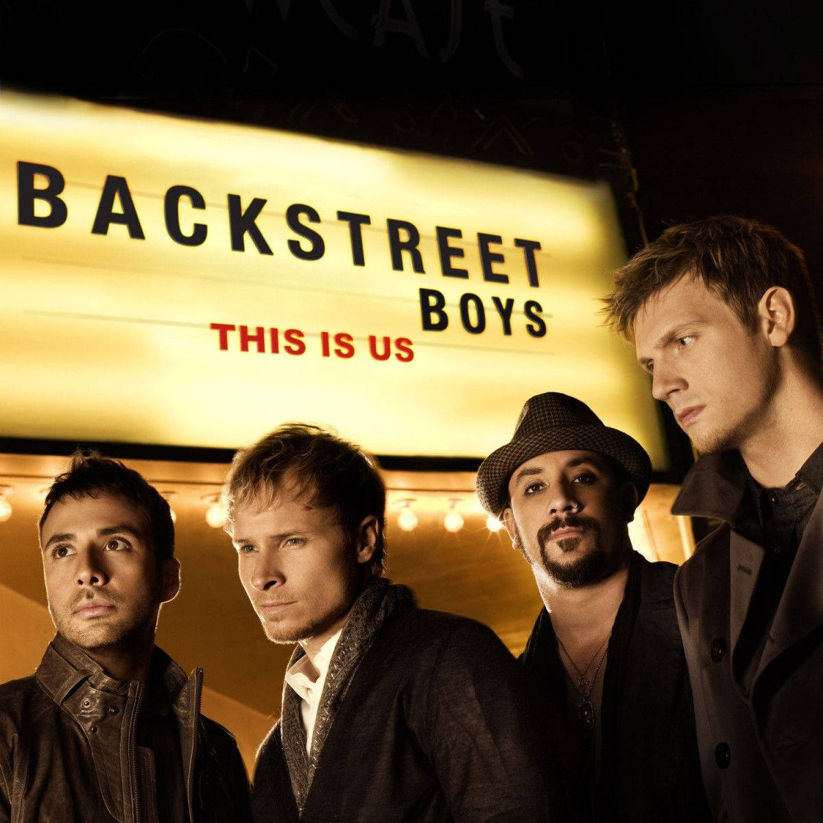 Backstreet 桌布 壁紙 — 四個男人夜晚站在發光的「BACKSTREET BOYS THIS IS US」招牌下，伴隨著溫暖的燈光。
