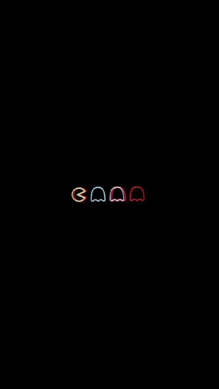 Dark Aesthetic Cartoon 桌布 壁紙 — 四個發光的 Pac-Man 鬼魂和一個 Pac-Man 以霓虹色彩漂浮在漆黑的背景上。
