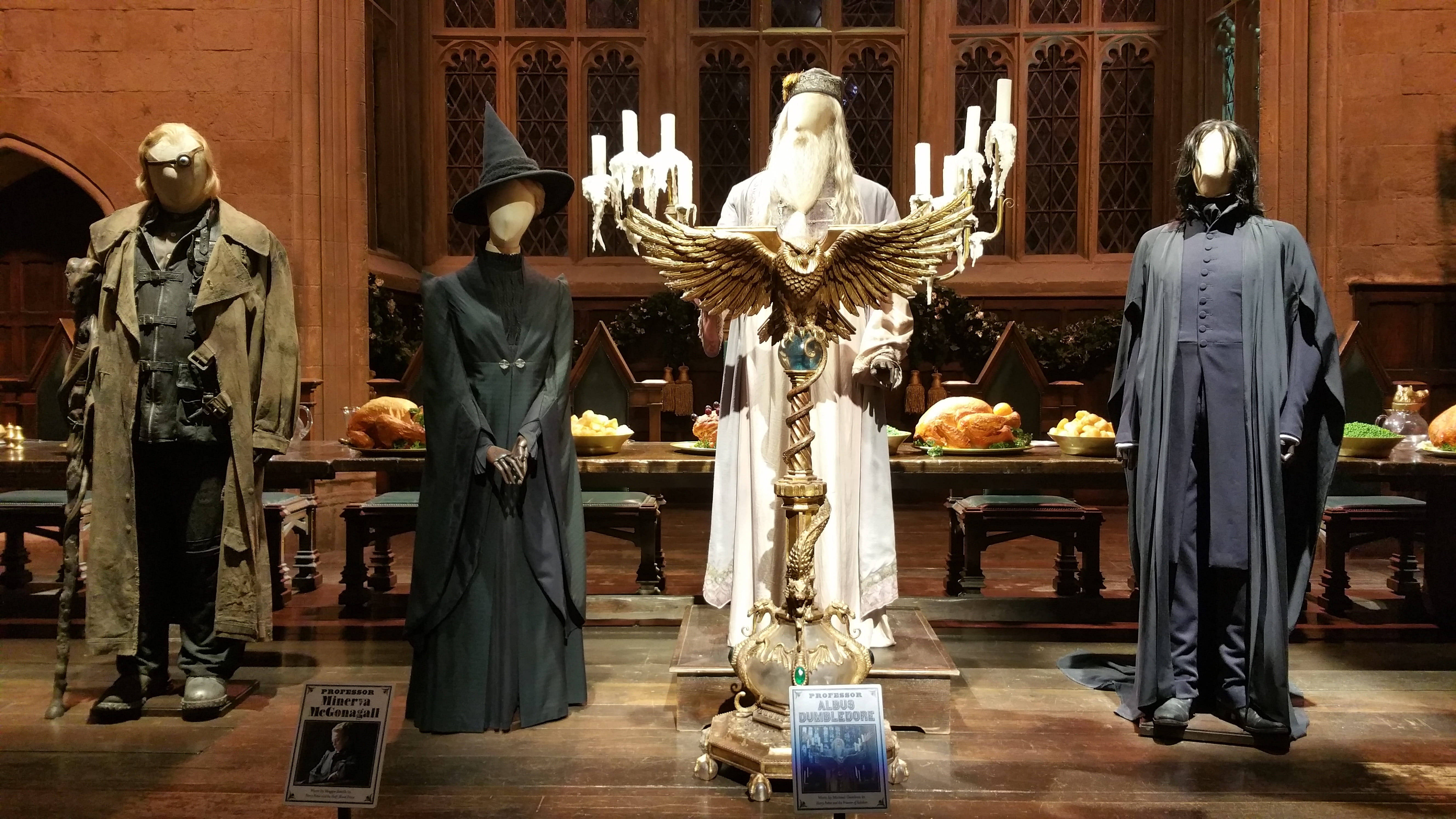 snape 桌布 壁紙 — 四個真人大小的哈利波特角色服裝站在一個有華麗窗戶和擺滿烤火雞的桌子的大廳中。