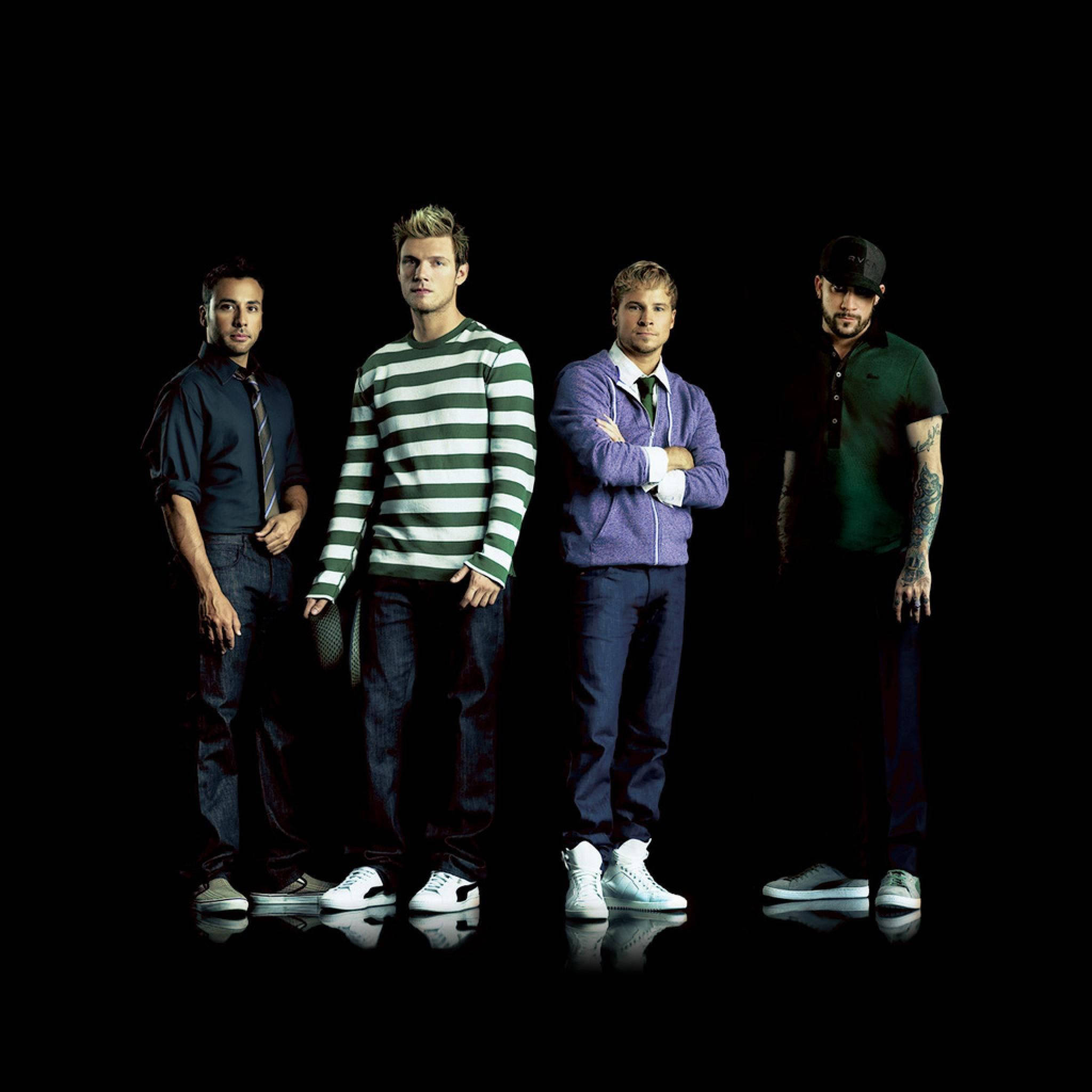 Backstreet 桌布 壁紙 — 四個穿著休閒服的男人自信地站在黑色背景和反光地板上。