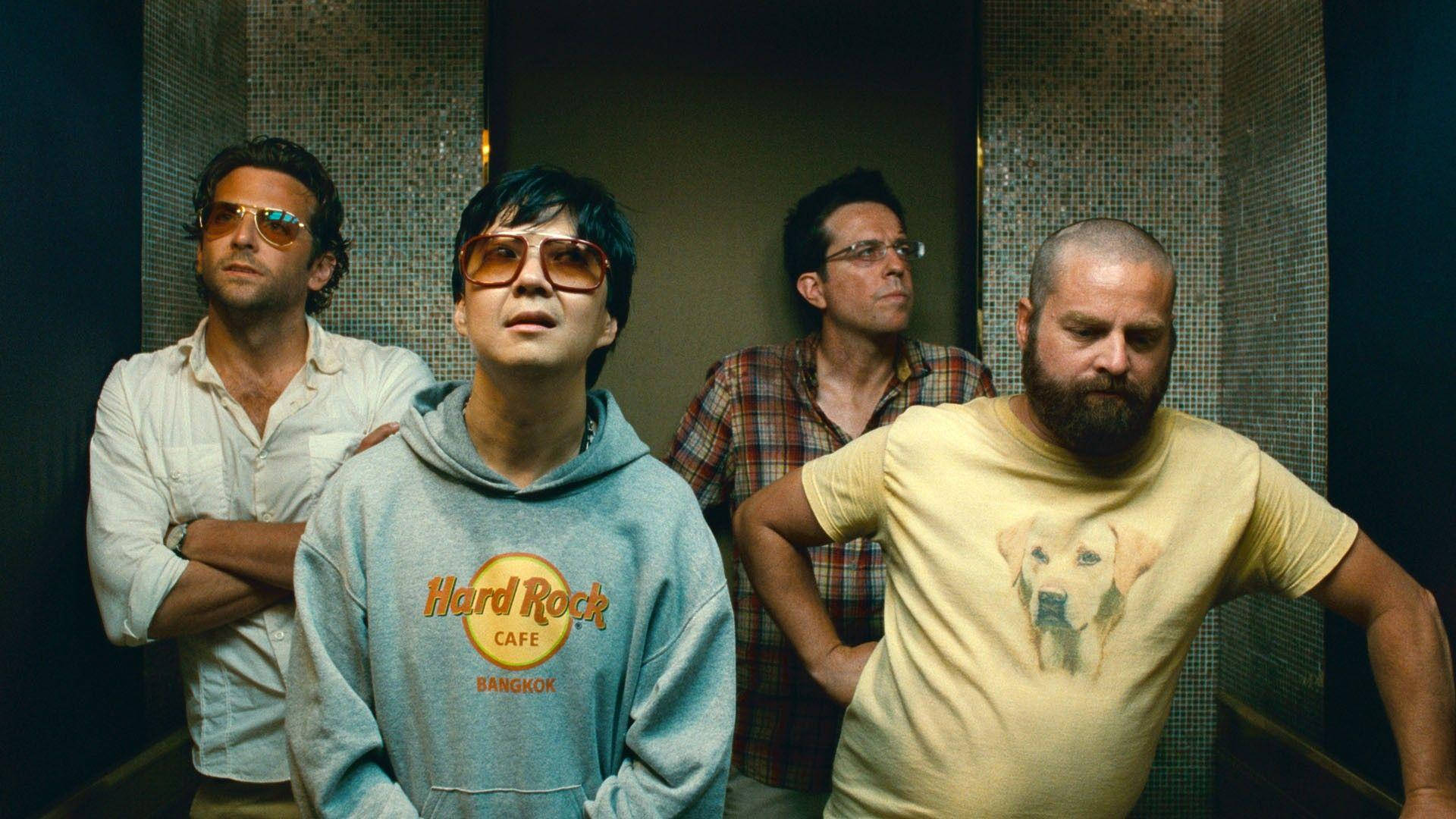 leslie chow 桌布 壁紙 — 四個穿著休閒服裝的男人站在一個有馬賽克瓷磚牆的電梯內，嚴肅地向上看。