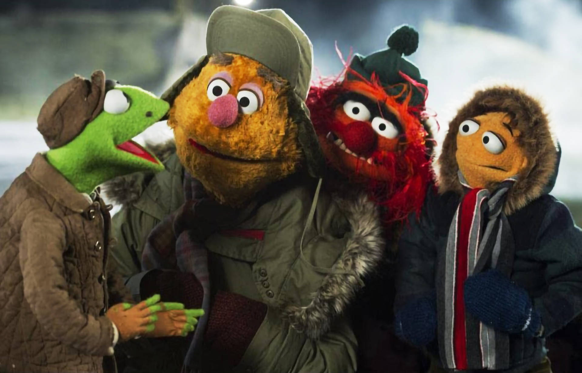 muppets 桌布 壁紙 — 四個穿著冬季外套和帽子的Muppet角色在雪景背景下站在一起。