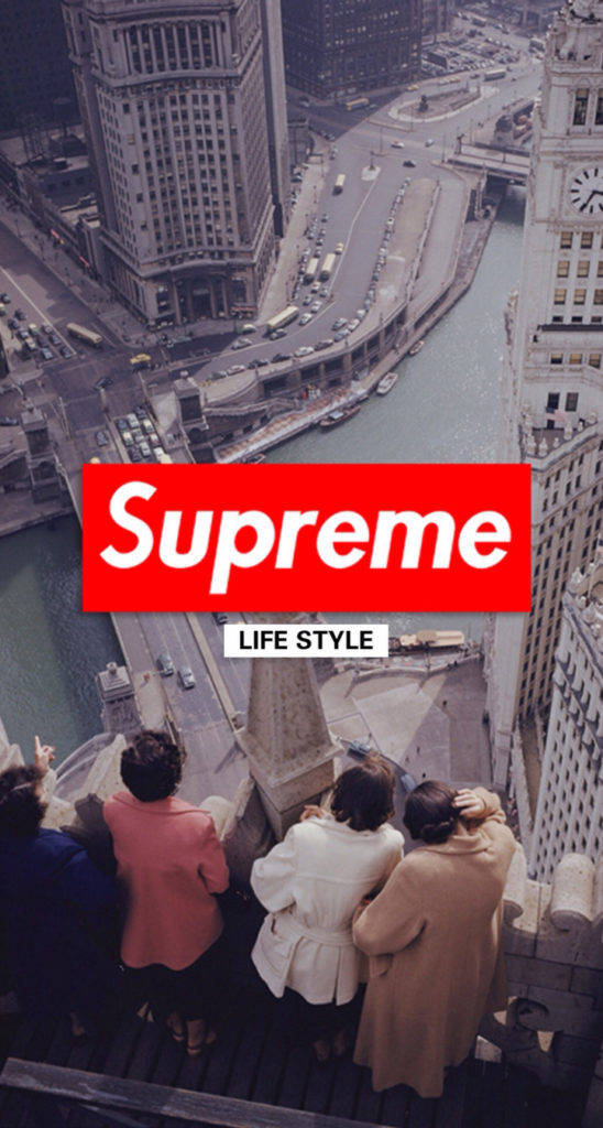 超屌 Supreme 桌布 壁紙 — 四個穿著外套的人俯瞰著蜿蜒的河流和城市景觀，下方有一個大膽的紅色Supreme標誌。