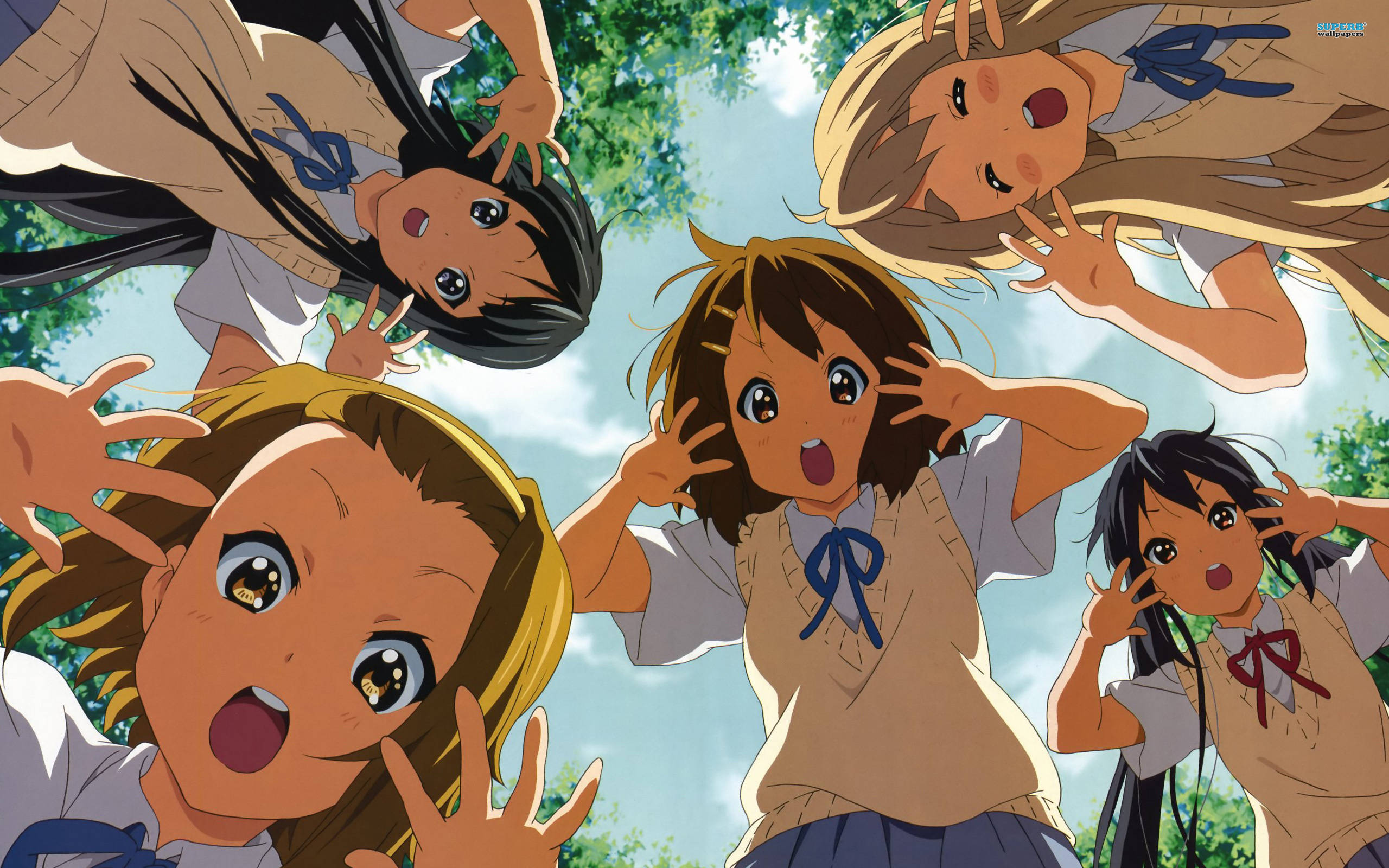 K-on 桌布 壁紙 — 四個穿著校服的動漫女孩在明亮的藍天和綠樹的襯托下，開心地伸出雙手圍繞著觀眾。