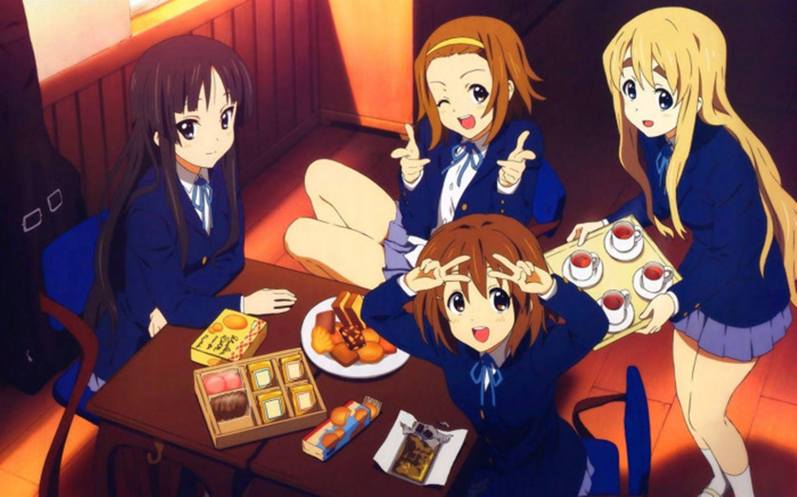Thanksgiving Aesthetic 桌布 壁紙 — 四個穿著校服的動漫女孩在燈光溫暖的房間裡圍著一張擺滿甜點和茶的桌子。
