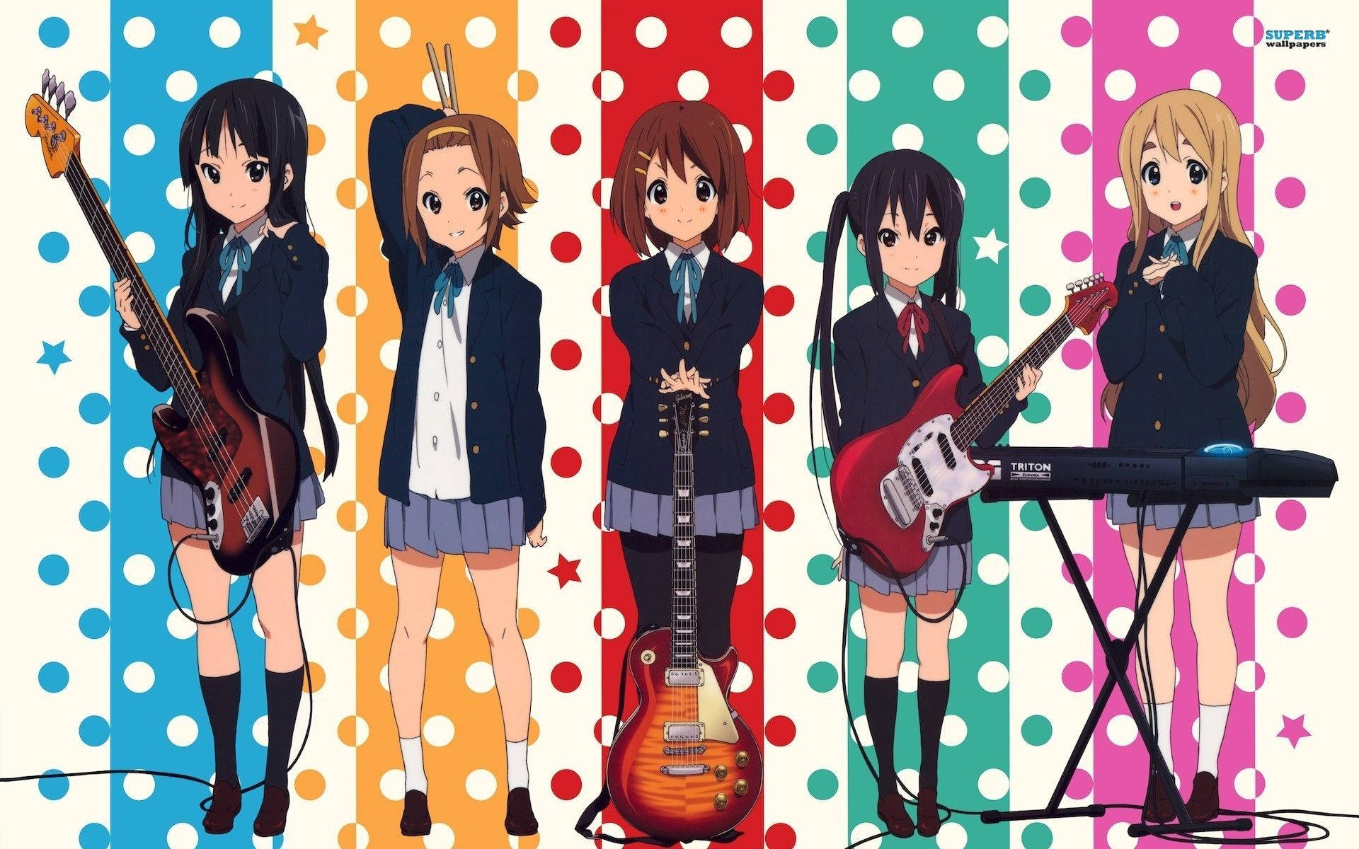 K-on 桌布 壁紙 — 四個穿著校服的動漫女孩在色彩繽紛的圓點條紋背景前彈奏吉他和鍵盤。