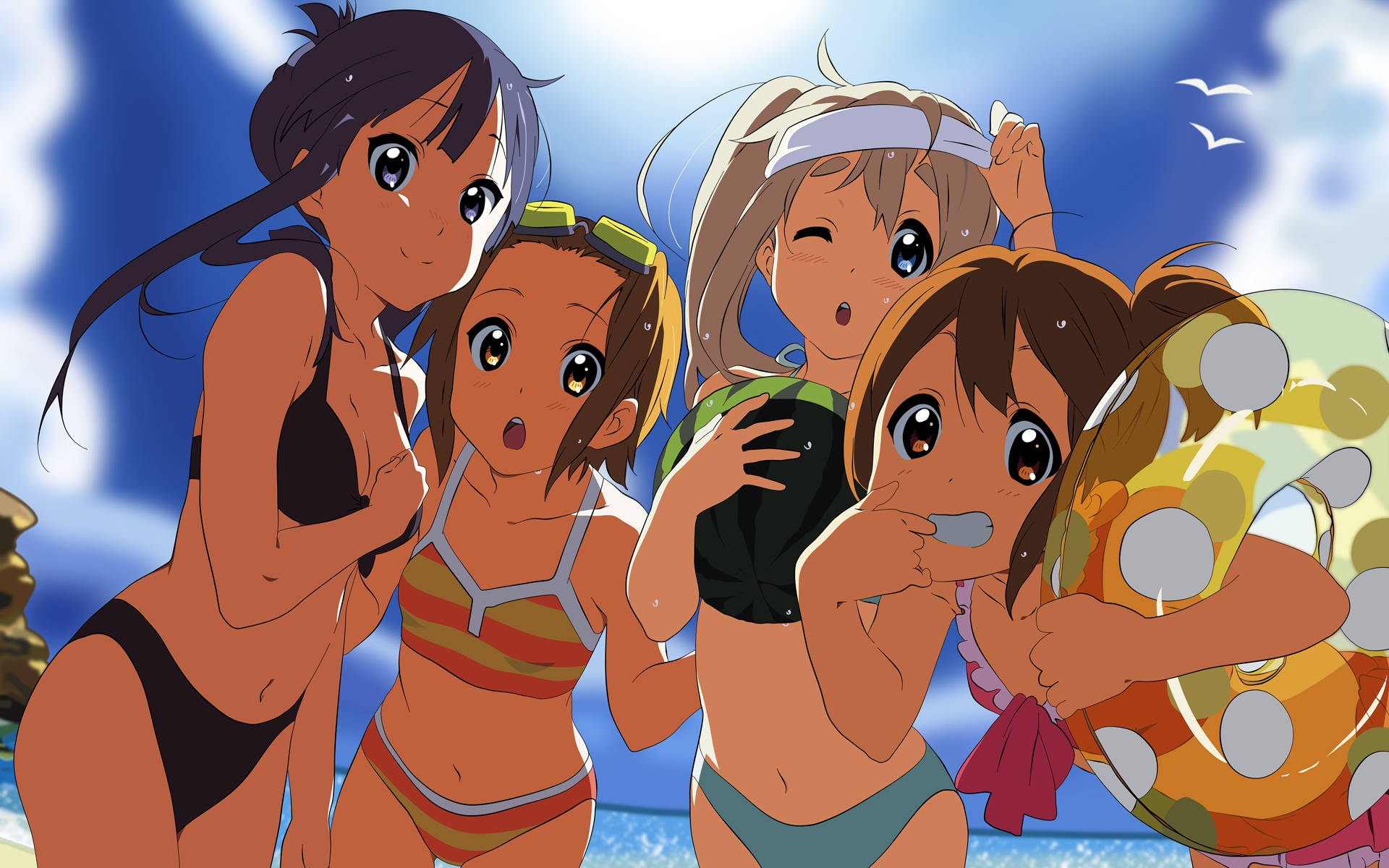 K-on 桌布 壁紙 — 四個穿著泳衣的動漫女孩在陽光明媚的海灘上笑著擺姿勢，藍天和海鷗在頭頂飛翔。
