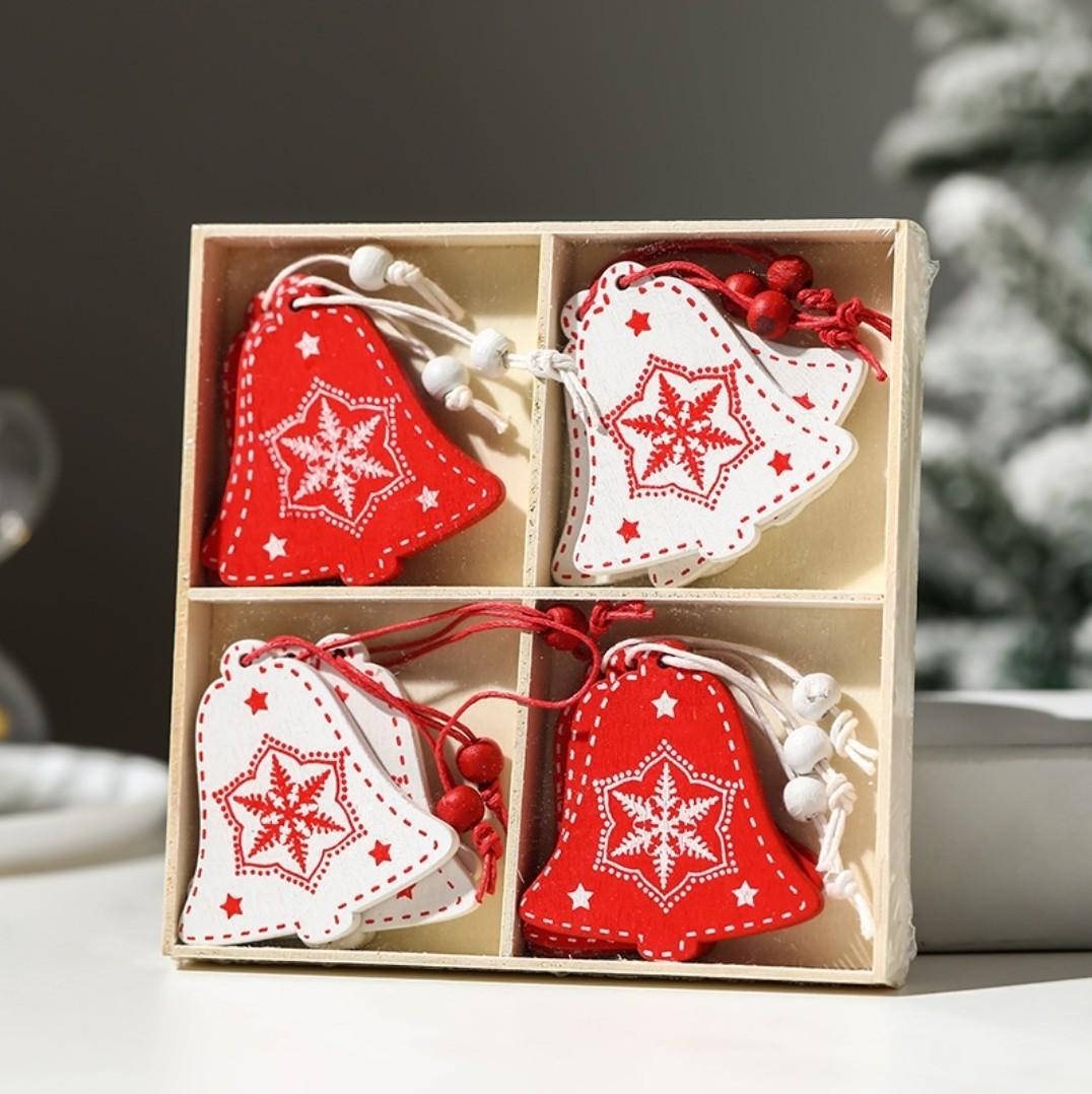 Christmas Bell 桌布 壁紙 — 四個紅白氈製鈴鐺裝飾品，帶有雪花刺繡，整齊地放在一個木盒裡，背景是雪樹。