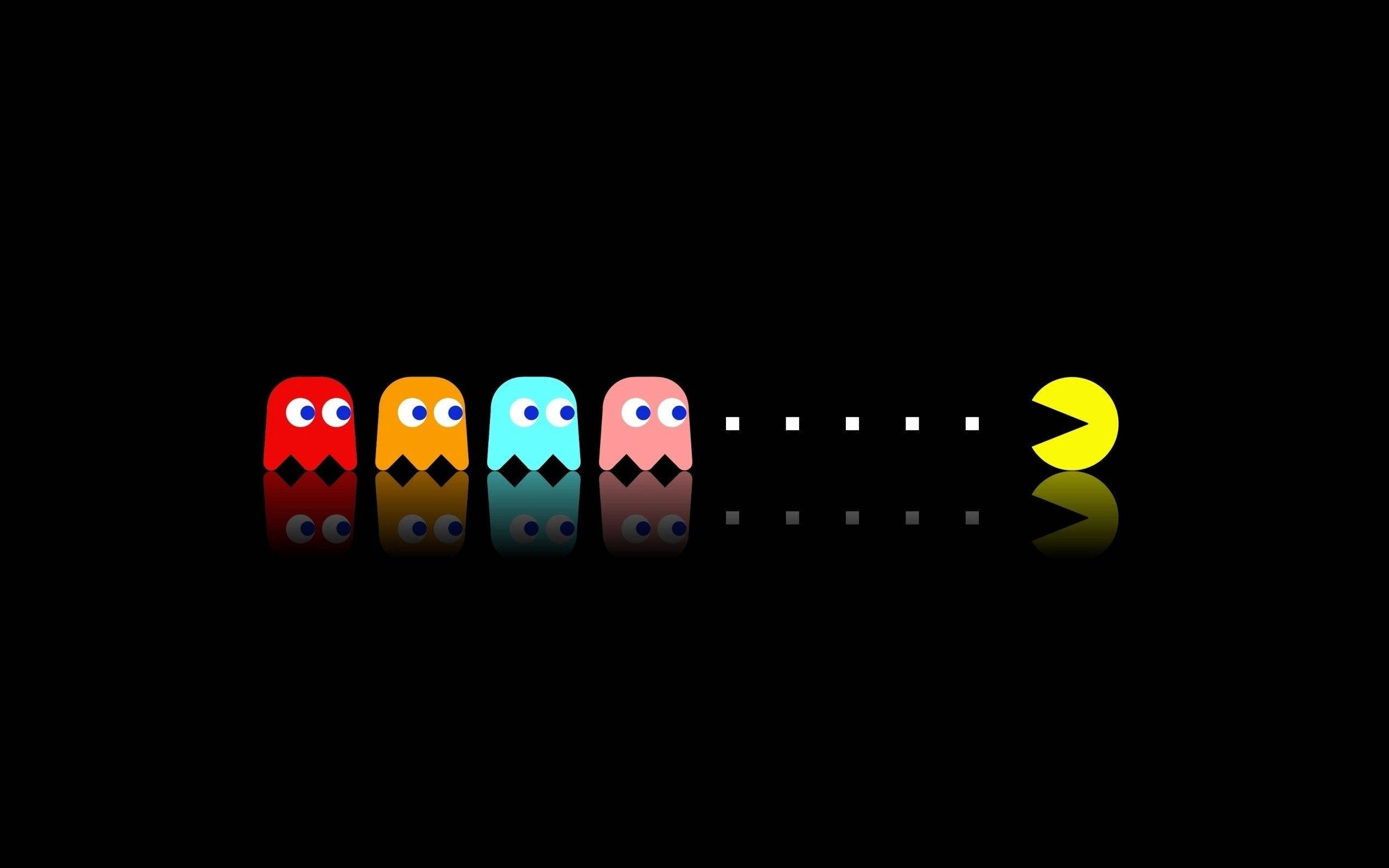 遊戲 桌布 壁紙 — 四個色彩繽紛的 Pac-Man 鬼魂排成一排，面向一個黃色 Pac-Man，站在黑色反光表面上。