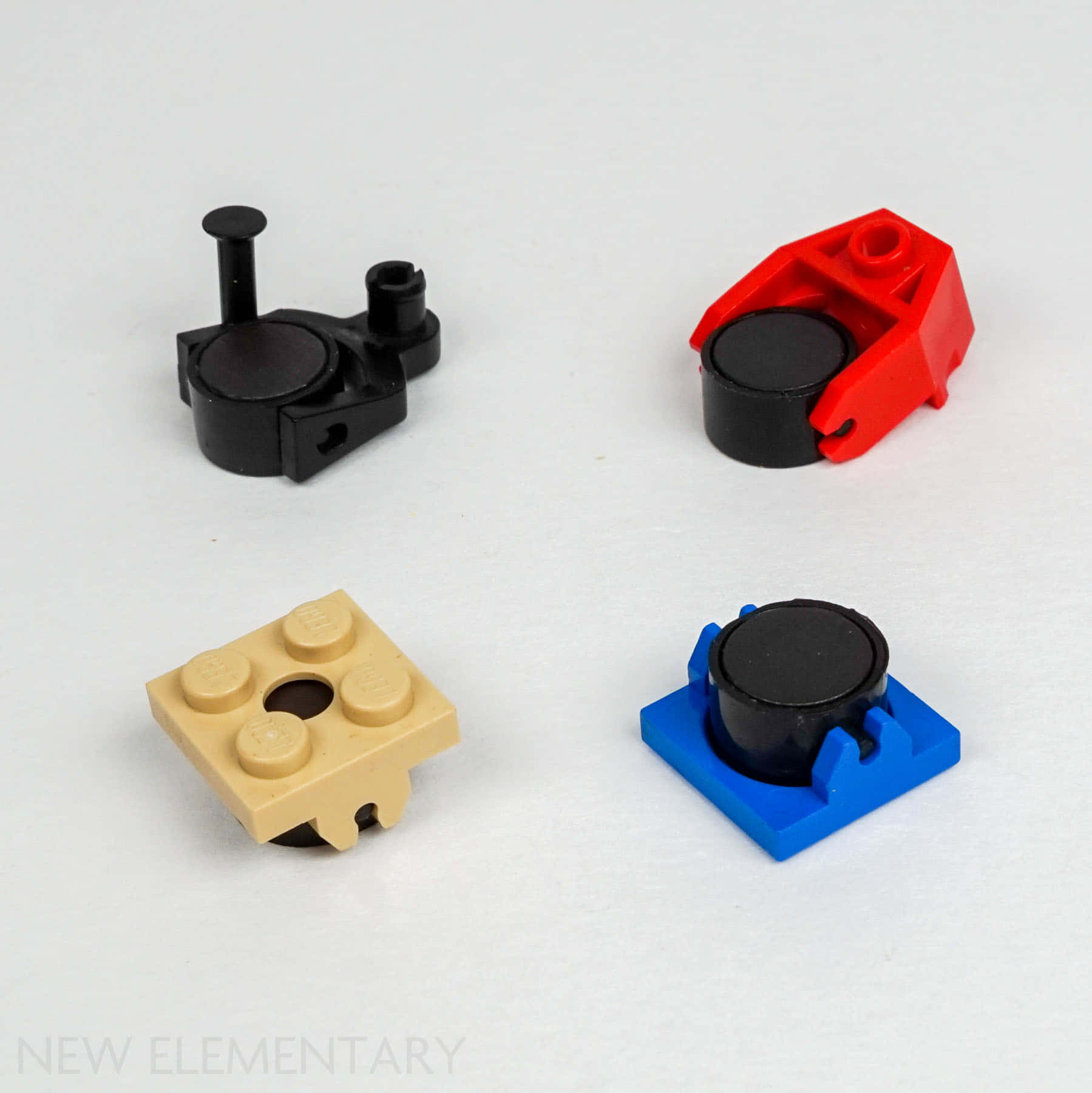 Material 桌布 壁紙 — 四個色彩繽紛的LEGO Technic零件，帶黑色輪轂，排列在純白色表面上。