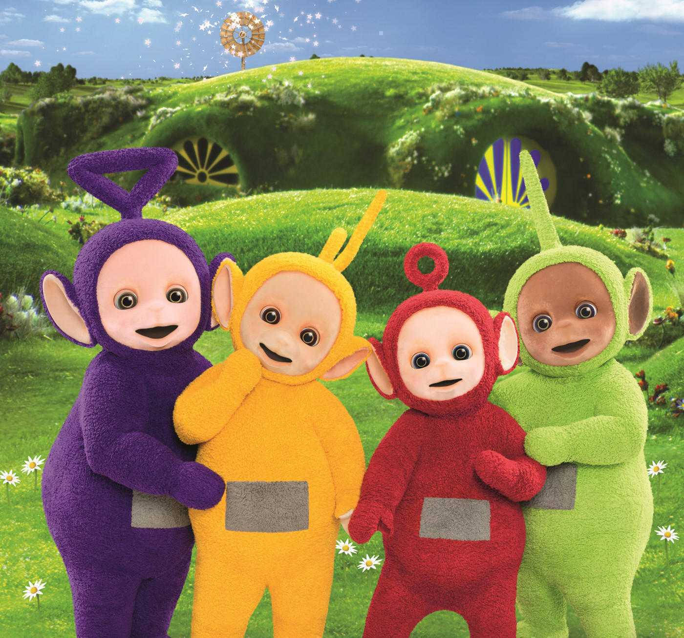 Cartoon 桌布 壁紙 — 四個色彩繽紛的Teletubbies微笑著站在充滿活力的綠色草地上，身後有一座奇特的丘陵小屋。