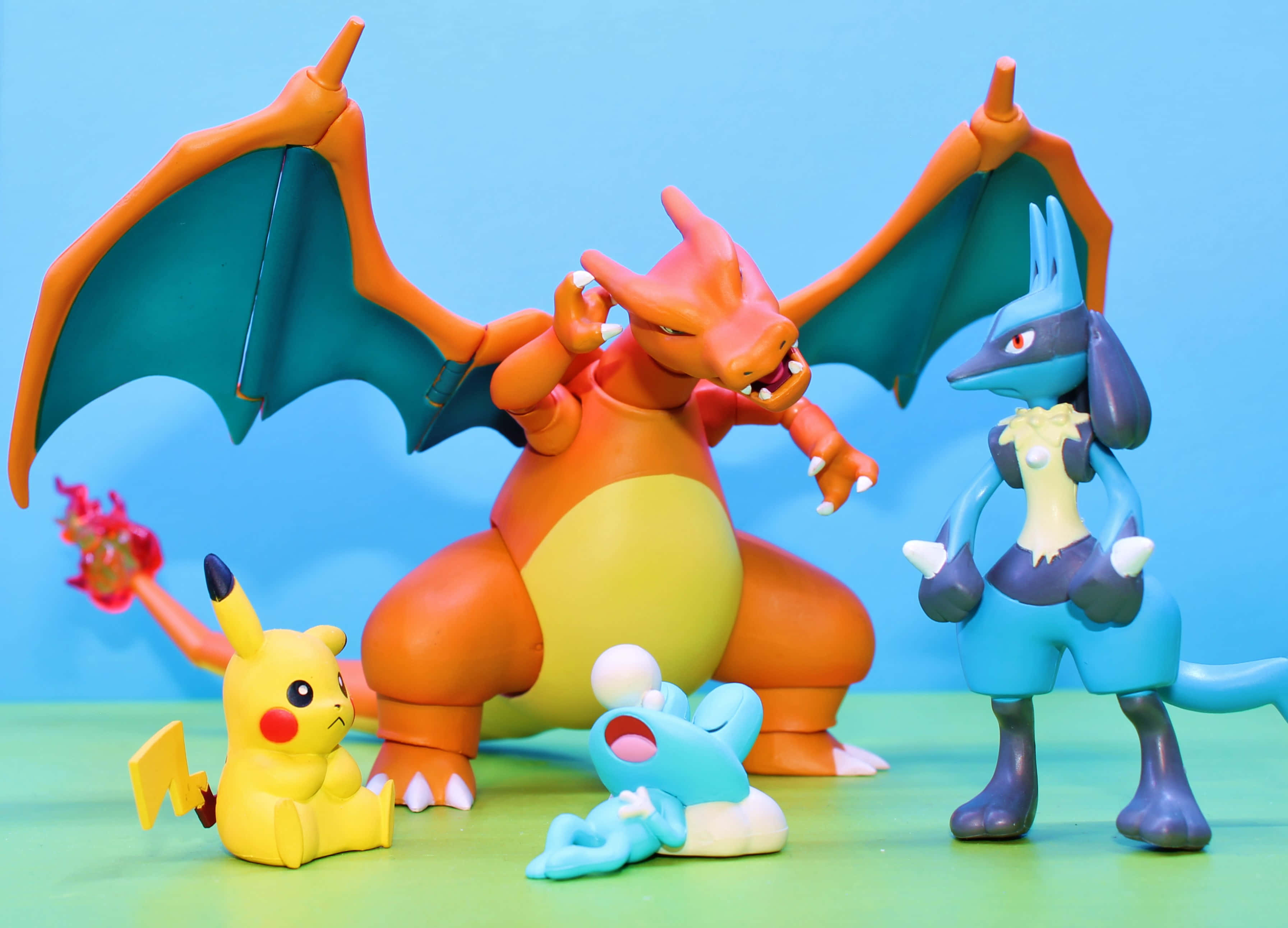 Pokemon Figures 桌布 壁紙 — 四個色彩繽紛的寶可夢動作公仔在純藍色背景上動態擺姿勢。