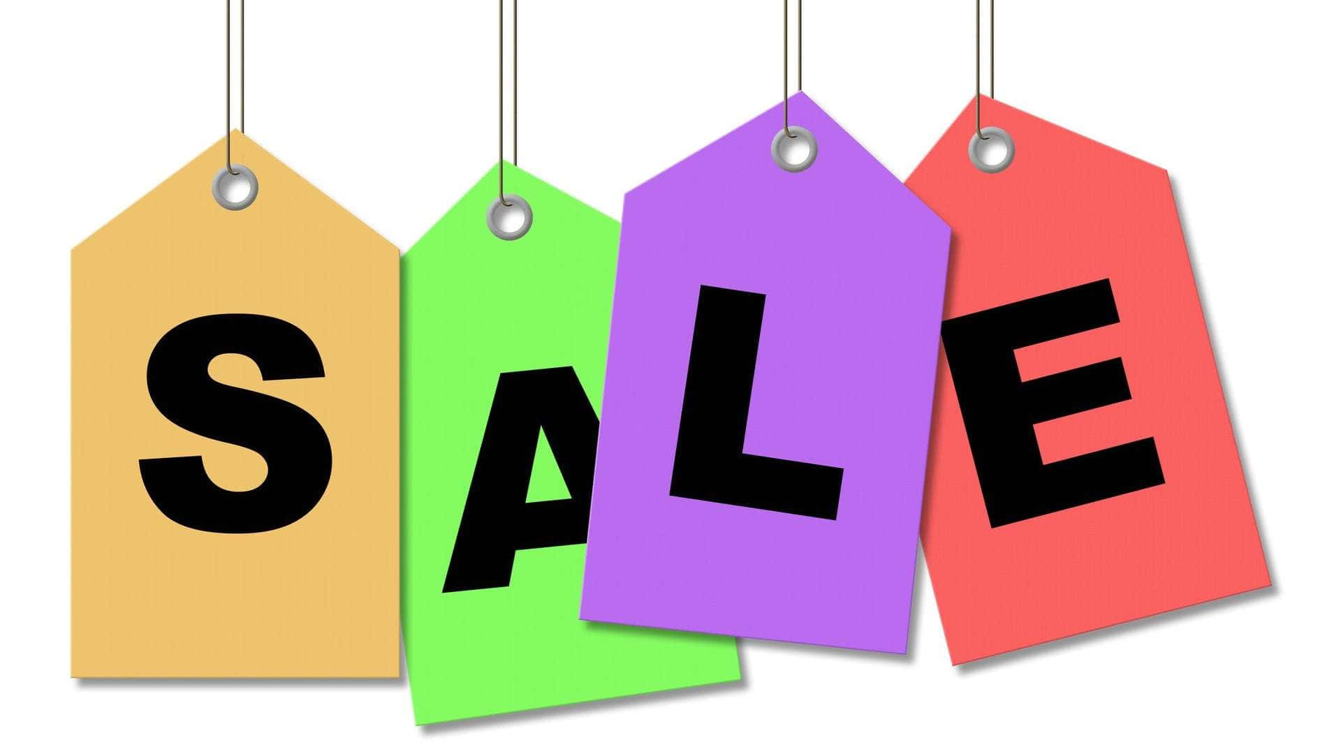 Sales 桌布 壁紙 — 四個色彩繽紛的懸掛式銷售標籤在潔白背景上以粗體黑色字母拼出 SALE。