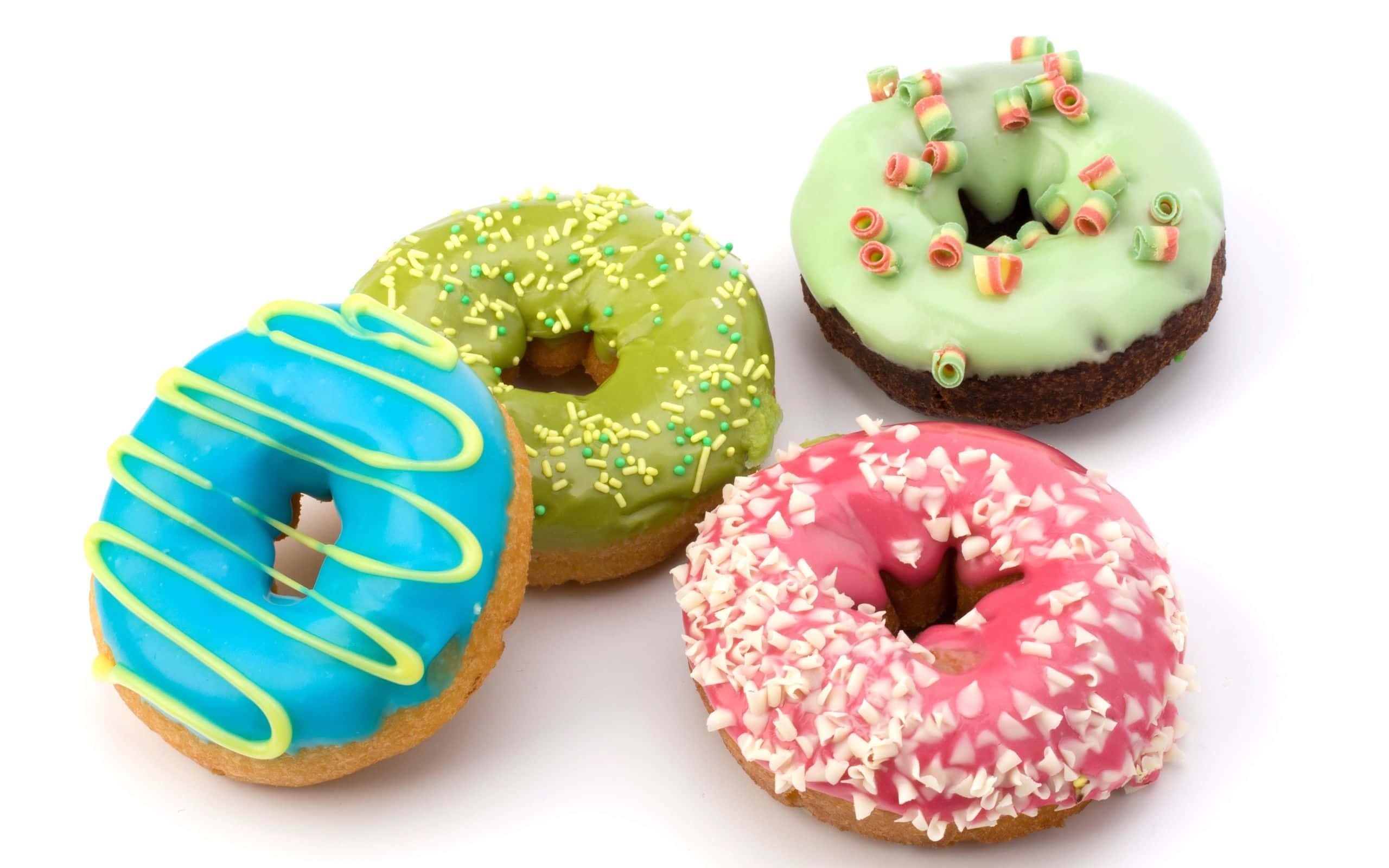 donuts 桌布 壁紙 — 四個色彩鮮豔的釉面甜甜圈，上面有彩色糖粒和淋醬，排列在乾淨的白色背景上。