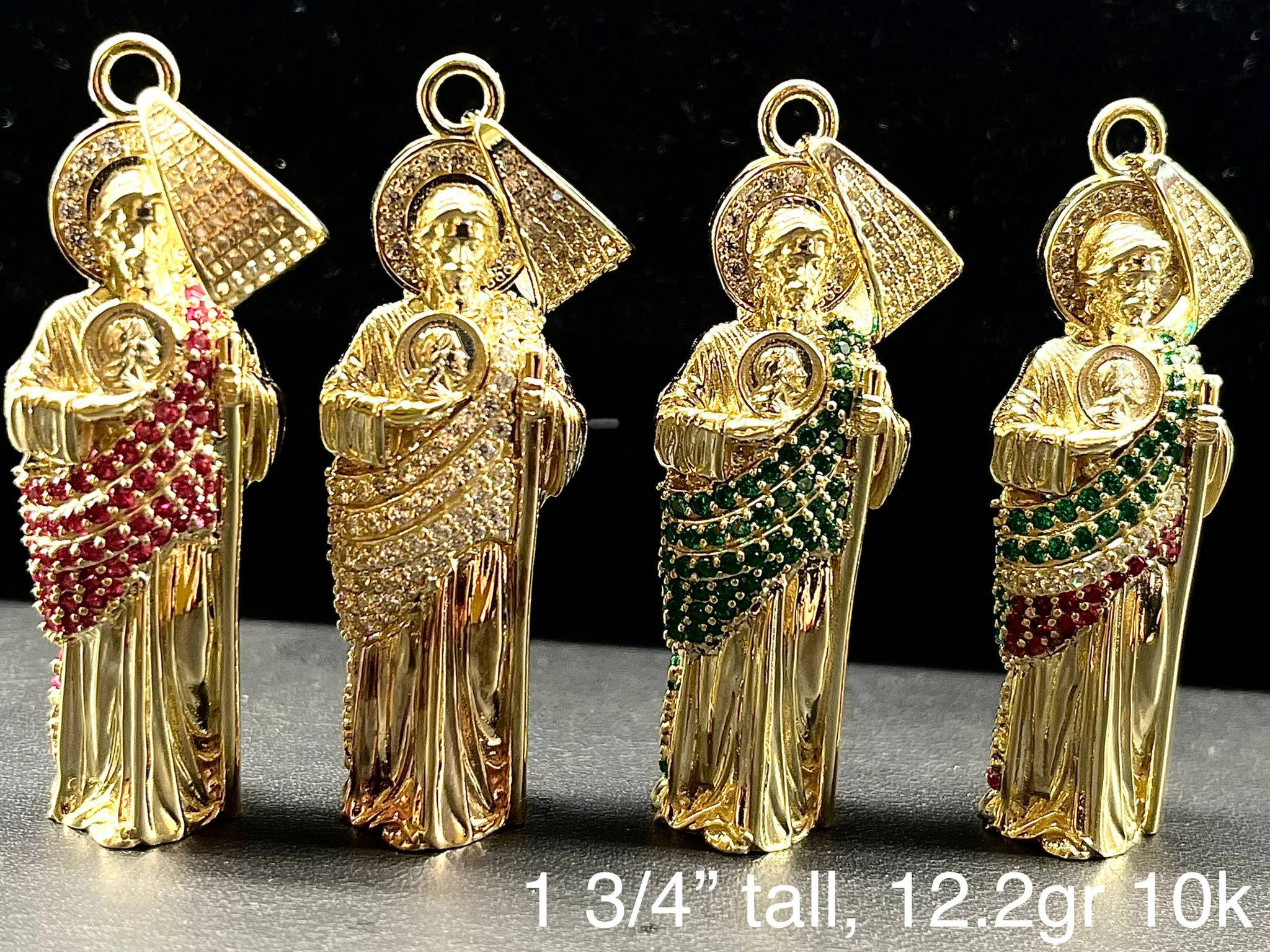 religion 桌布 壁紙 — 四個華麗的金色宗教吊墜，飾有紅色和綠色寶石，在深色背景前排列成一行。