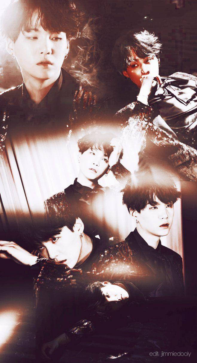Suga Bts 桌布 壁紙 — 四個身穿深色閃亮服裝的男人在溫暖的聚光燈下，在煙霧瀰漫的昏暗背景前戲劇性地擺姿勢。