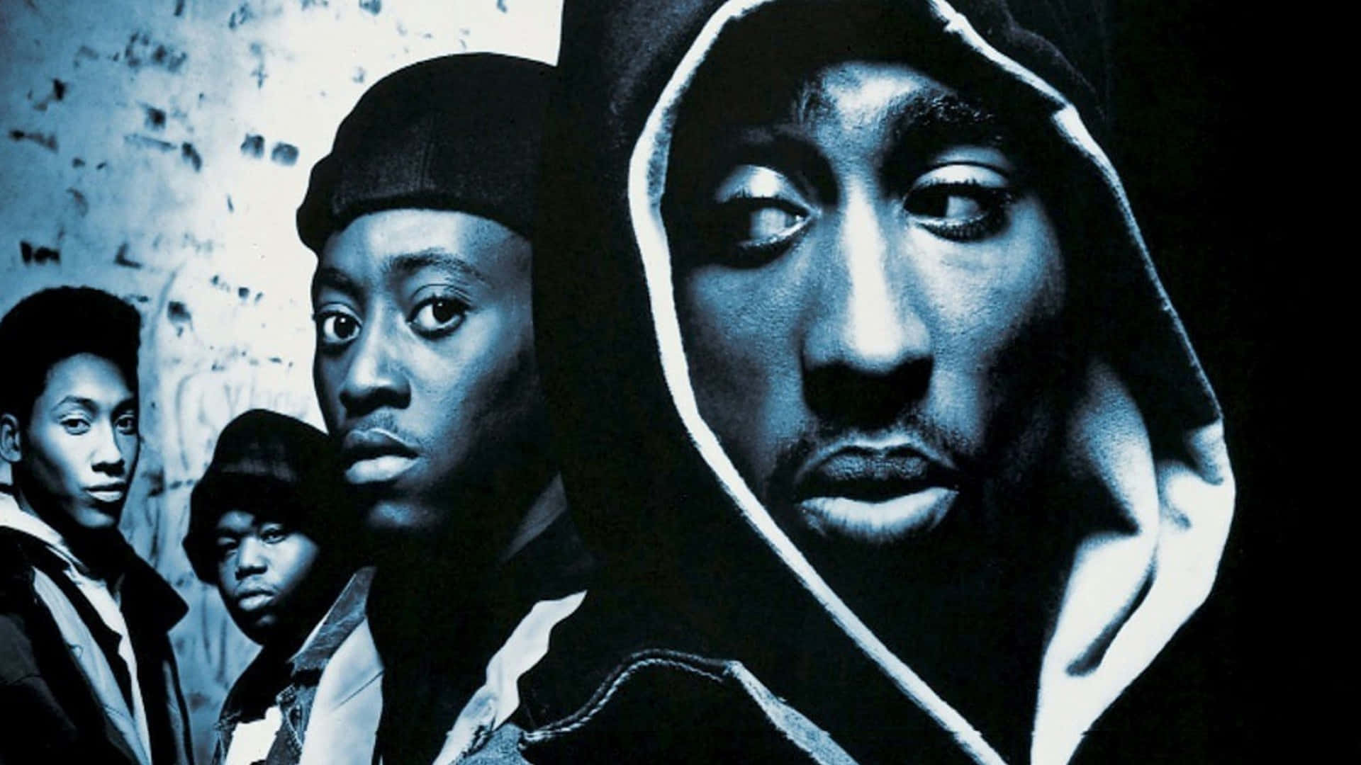 tupac 桌布 壁紙 — 四個身穿連帽衫和戴帽子的年輕男子在戲劇性的藍色燈光下，對著佈滿塗鴉的牆壁凝視。