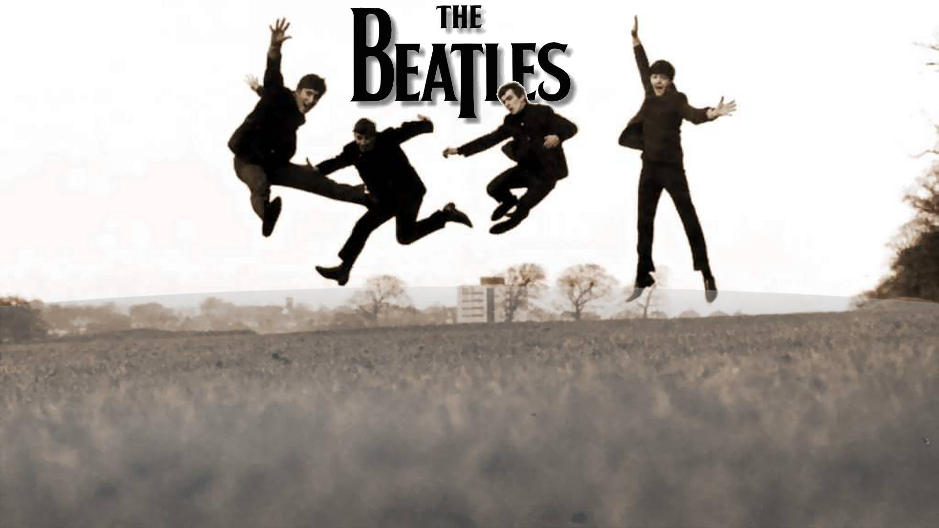 the beatles 桌布 壁紙 — 四個身穿黑色西裝的男人在晴朗的天空下，在一片草地上歡快地跳躍，上方有「The Beatles」字樣。