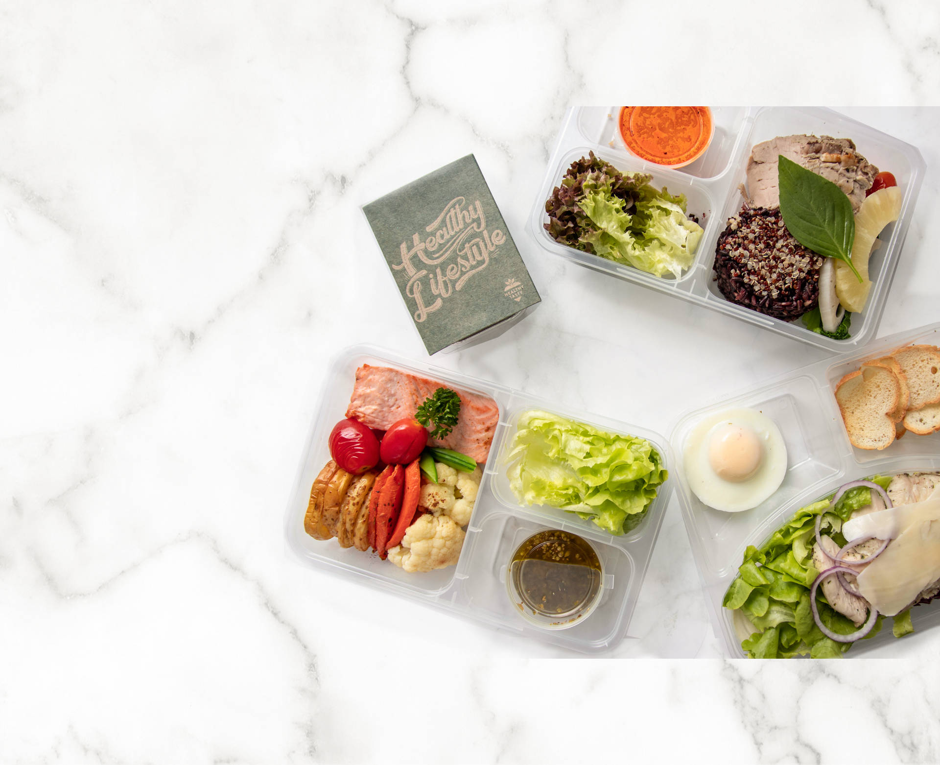 Healthy Food 桌布 壁紙 — 四個透明便當盒裝滿色彩繽紛的健康餐點，排列在白色大理石表面上。