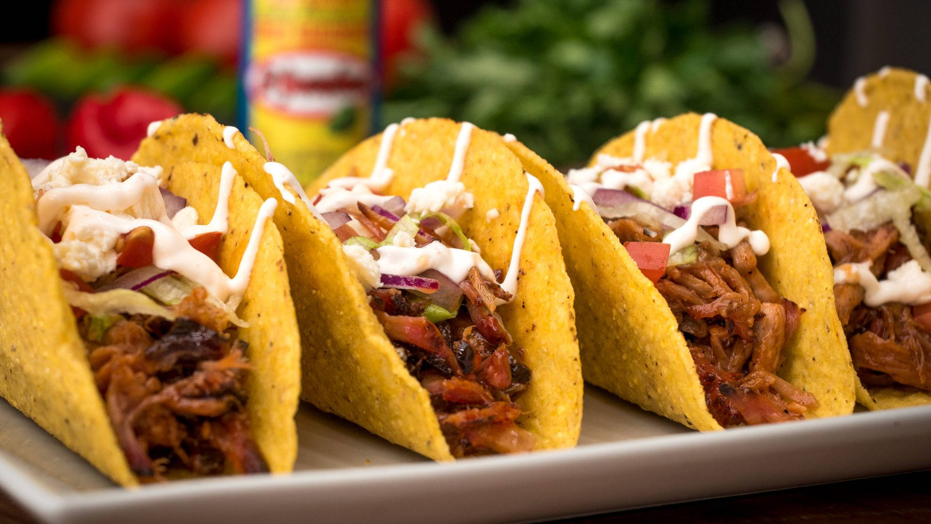 Mexican Food 桌布 壁紙 — 四個金黃色的玉米餅，裡面塞滿了撕碎的肉、洋蔥、番茄和奶油醬，誘人地擺在一個白色盤子上。