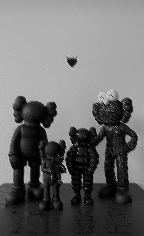 kaws pc 桌布 壁紙 — 四個霧面黑色KAWS公仔大小不一，站在深色表面上，上方有一個漂浮的心形，背景是素牆。