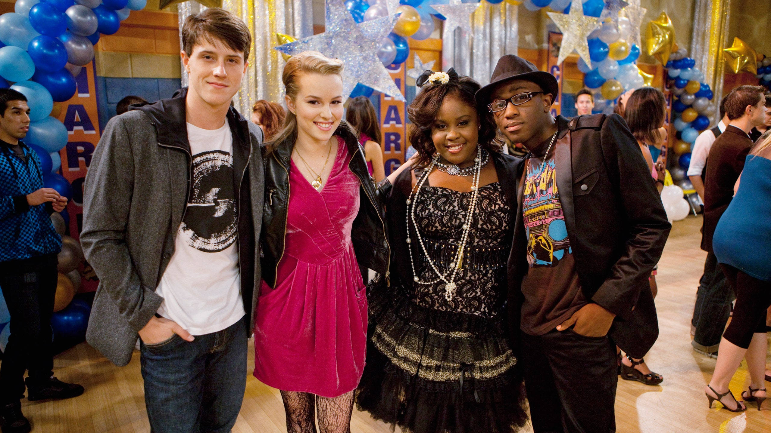 Good Luck Charlie 桌布 壁紙 — 四個青少年在一個充滿活力的學校舞會中一起擺姿勢，背景有藍色金色氣球和閃爍星星。
