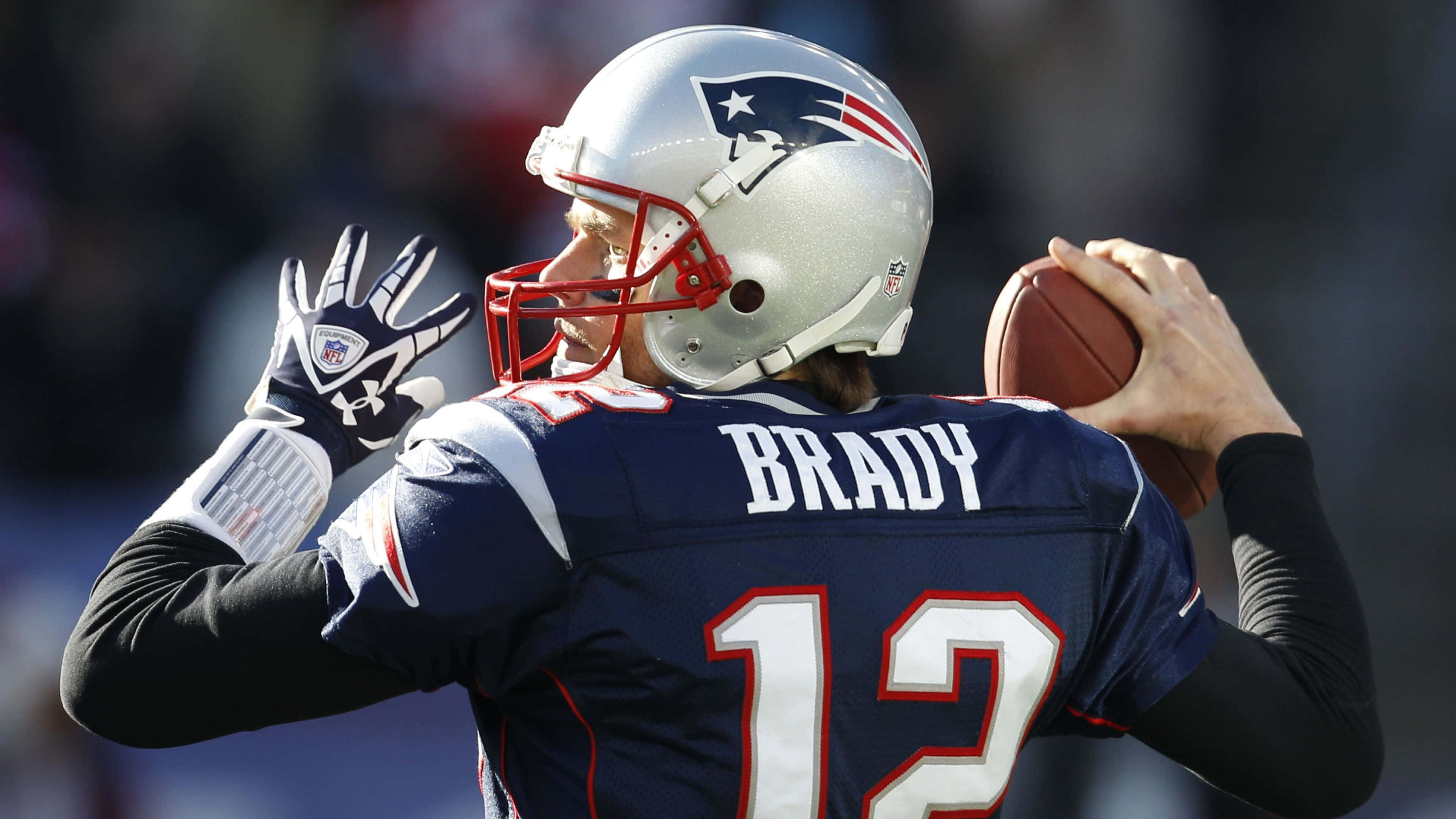 Tom Brady Goat 桌布 壁紙 — 四分衛湯姆·布雷迪身穿新英格蘭愛國者隊球衣，在日間比賽中準備擲出橄欖球。