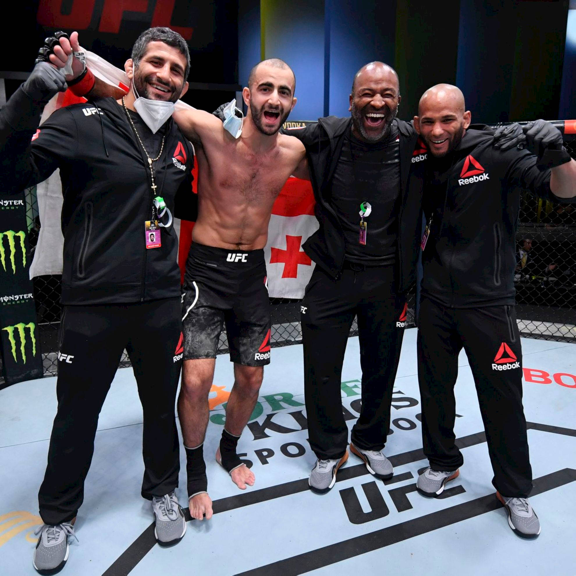 Champion 桌布 壁紙 — 四名男子在UFC八角籠中互相擁抱，帶著勝利的喜悅表情慶祝。