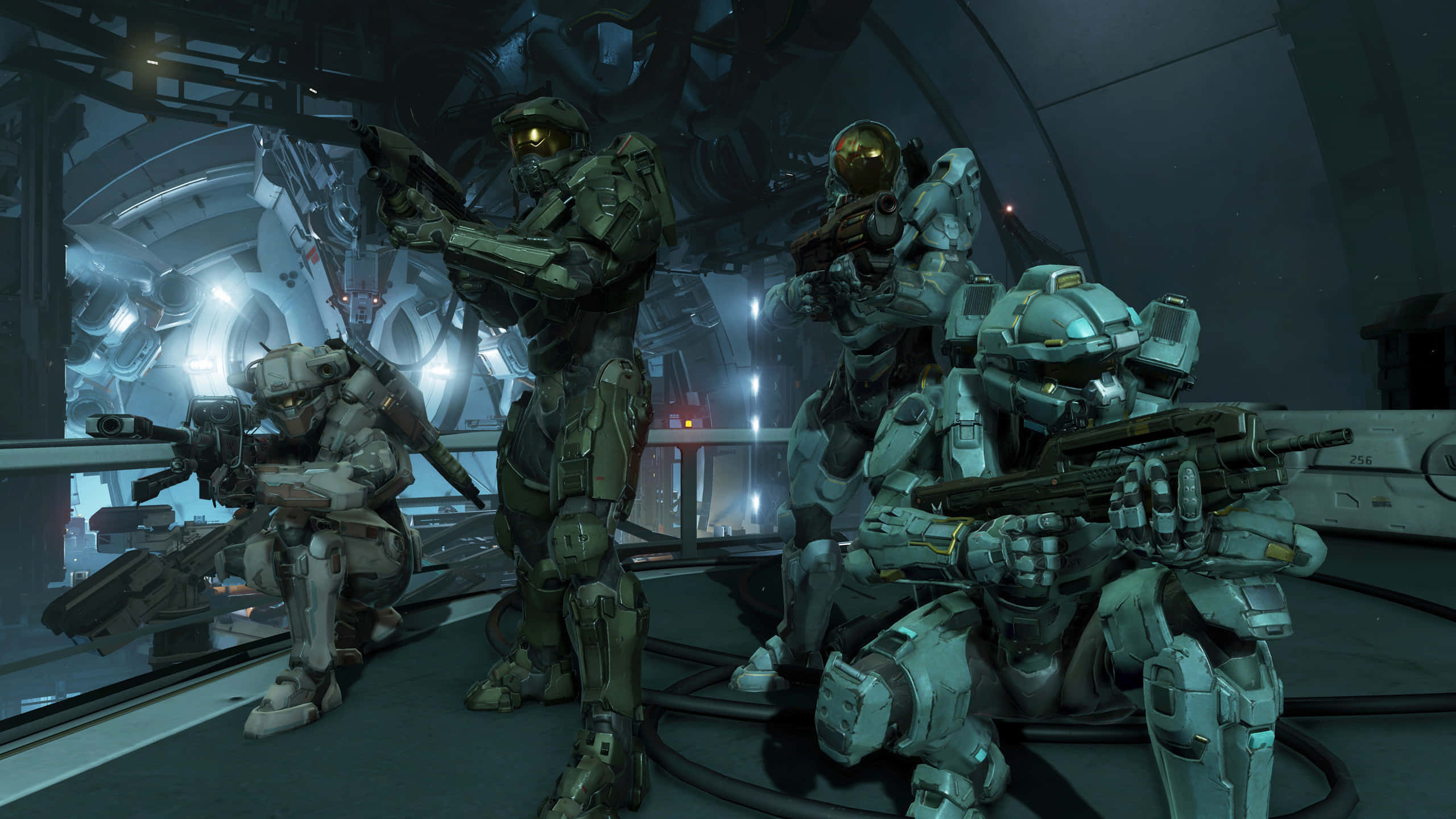 Halo 5 Blue Team 桌布 壁紙 — 四名身穿未來戰鬥裝備的裝甲士兵在光線昏暗、帶有發光燈光和金屬結構的科幻走廊中保持警覺。