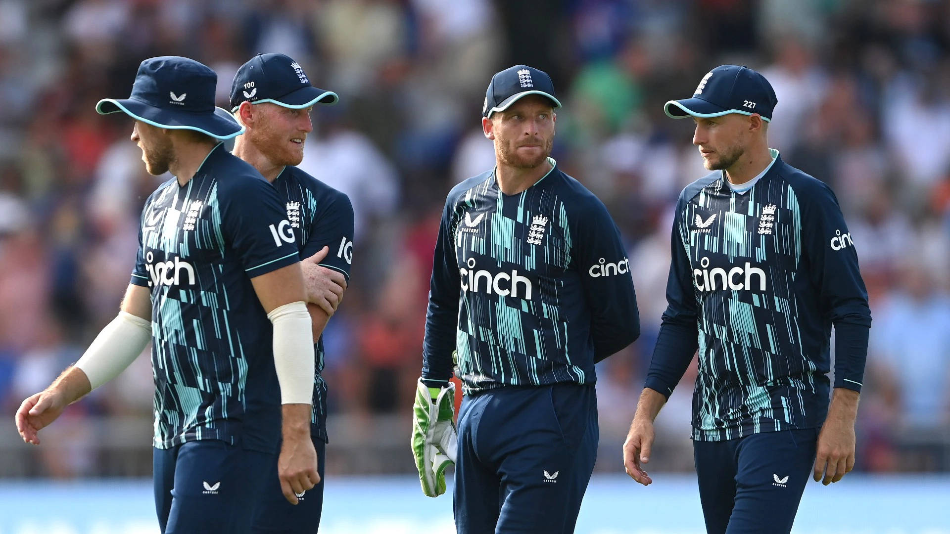 jos buttler 桌布 壁紙 — 四名身穿海軍藍和青綠色球衣的英格蘭板球運動員，帶著專注的表情步出球場。