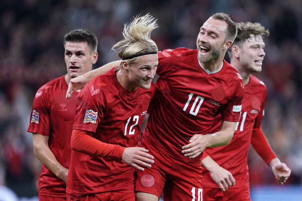 Football Players 桌布 壁紙 — 四名身穿紅色球衣的丹麥足球員在球場上瘋狂慶祝進球，充滿喜悅與活力。