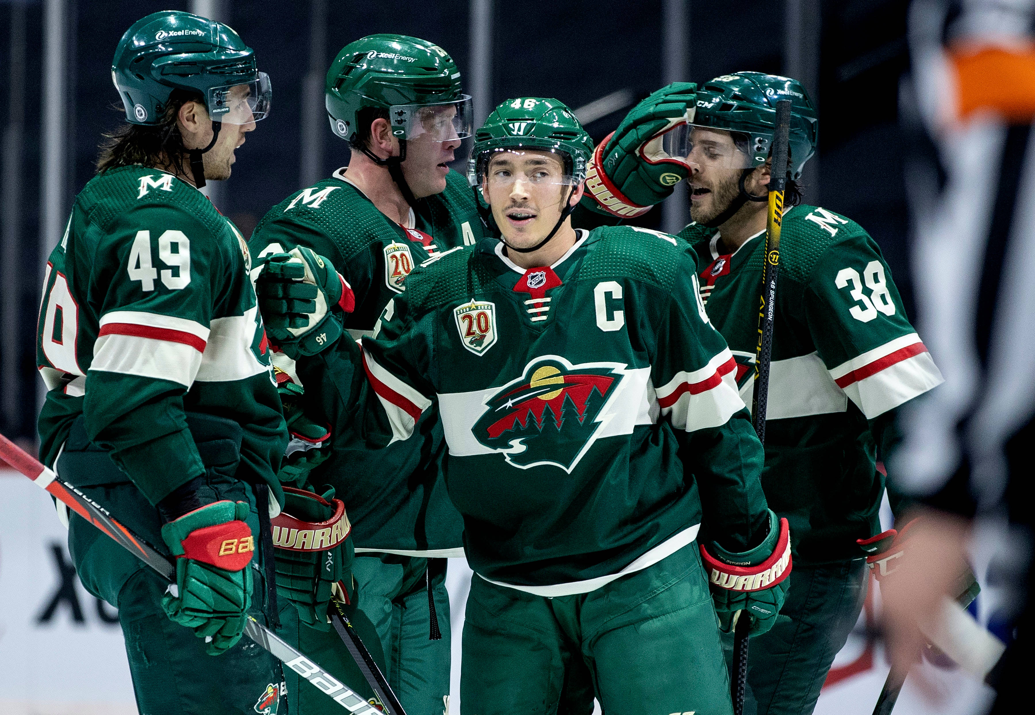 hockey 桌布 壁紙 — 四名身穿綠色球衣的曲棍球運動員戴著頭盔和球棍在冰上慶祝進球。