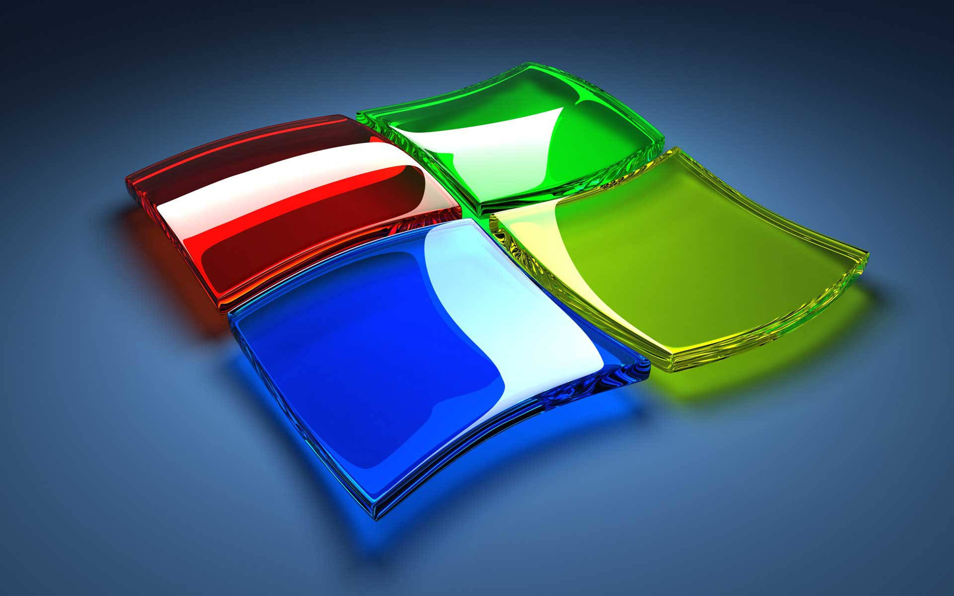 Computer Screen 桌布 壁紙 — 四塊光滑的彩色玻璃面板，分別為紅色、綠色、藍色和黃色，以Windows標誌形狀排列在深藍色漸變背景上。