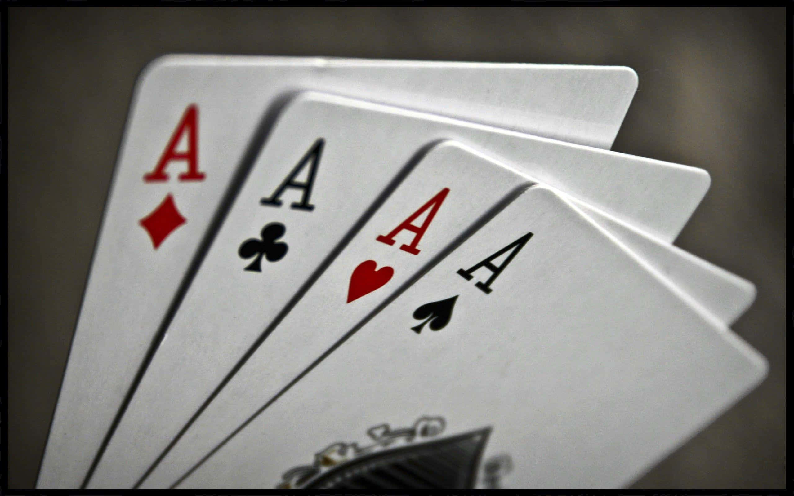 Poker 桌布 壁紙 — 四張Ace以扇形展開，在柔和的灰色背景上以戲劇性燈光清晰對焦。