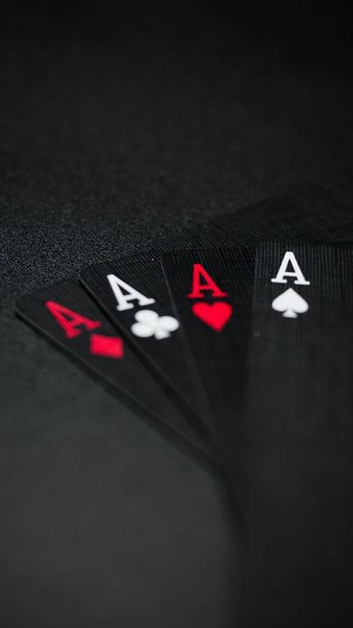 桌布 壁紙 — 四張Ace撲克牌在深色紋理表面上展開，景深較淺。
