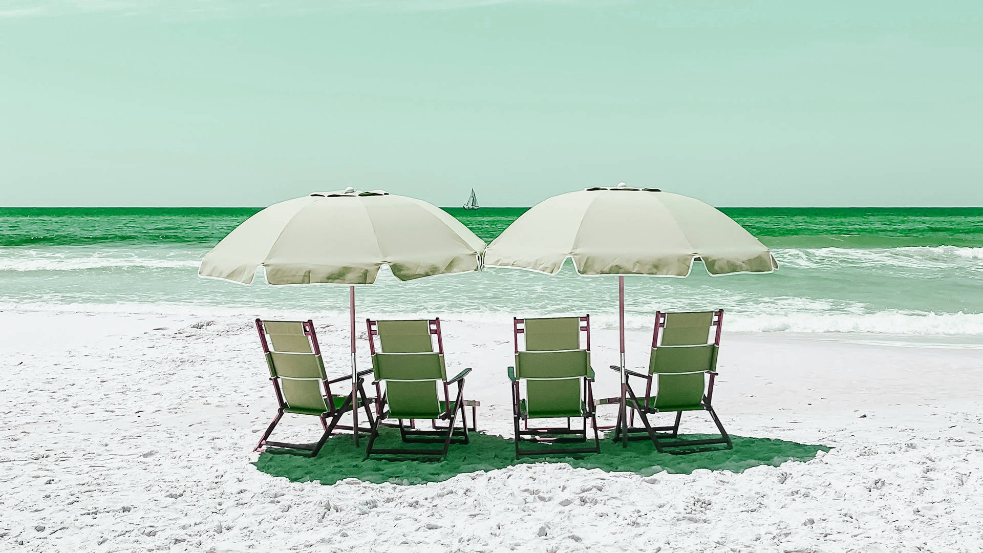 Beach Vacation 桌布 壁紙 — 四張綠色沙灘椅在白色沙灘上的白色遮陽傘下，面向有帆船在遠方的碧綠海洋。