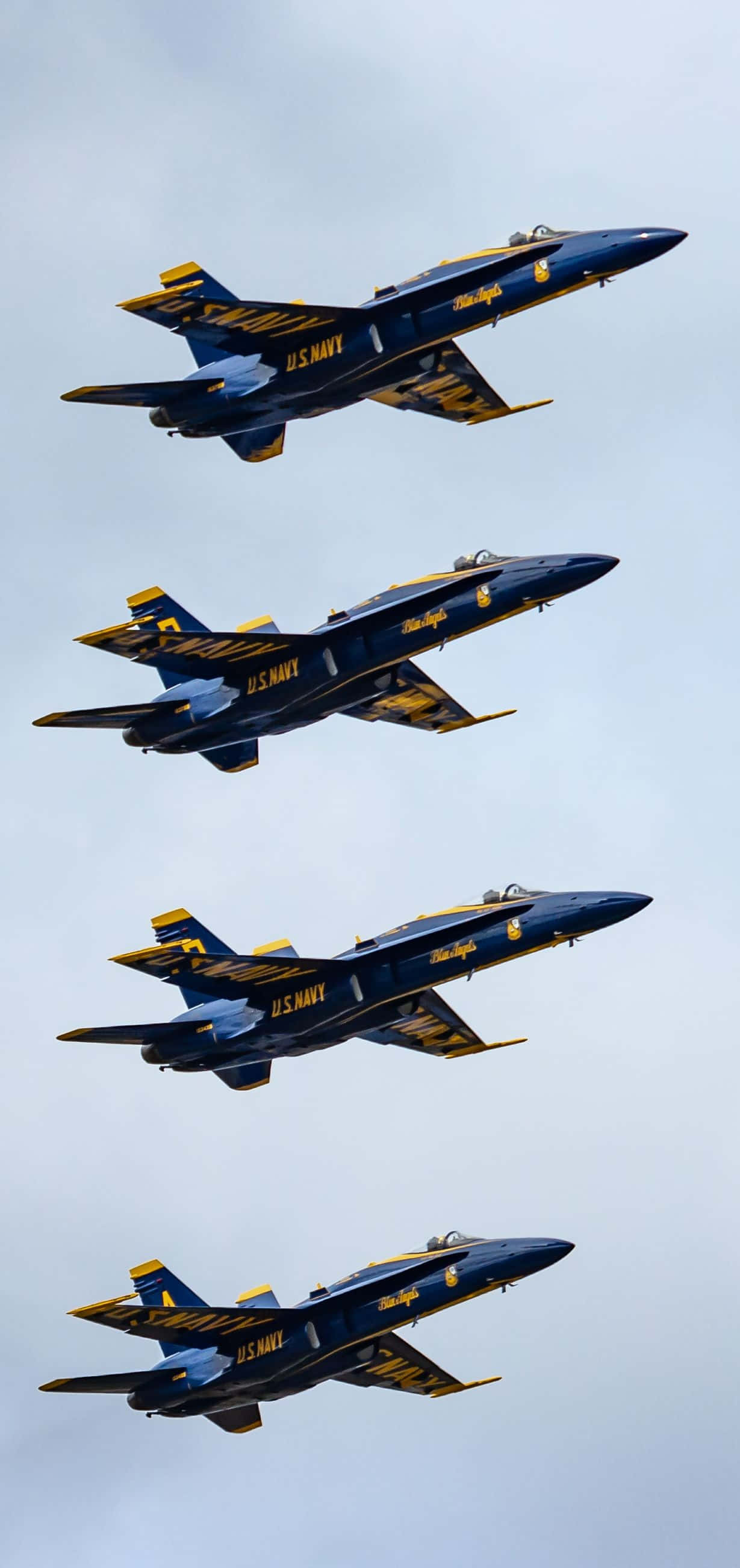 US Navy 桌布 壁紙 — 四架美國海軍藍天使噴射機在蒼白的天空中緊密編隊飛行，展現精準與空中實力。