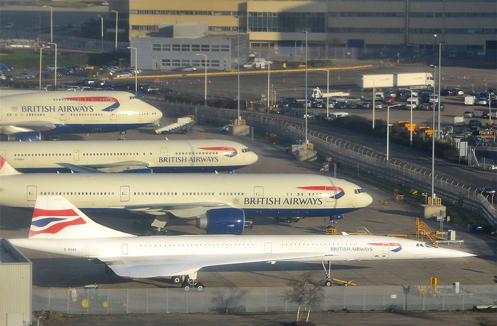 Airport 桌布 壁紙 — 四架英國航空飛機停泊在機場停機坪，背景有航廈建築和車輛。