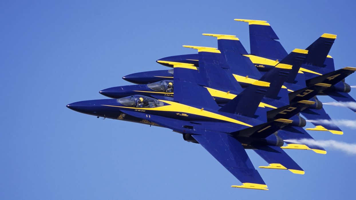 US Navy 桌布 壁紙 — 四架藍天使噴射機在清澈的藍天下緊密編隊飛行，留下白色煙跡。