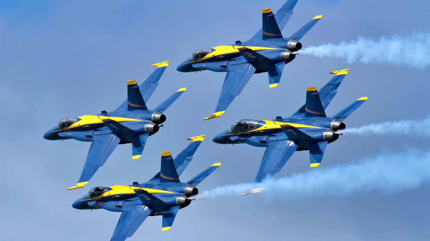 US Navy 桌布 壁紙 — 四架藍黃色戰鬥機在清澈的藍天中以緊密編隊飛行，留下白色煙跡。
