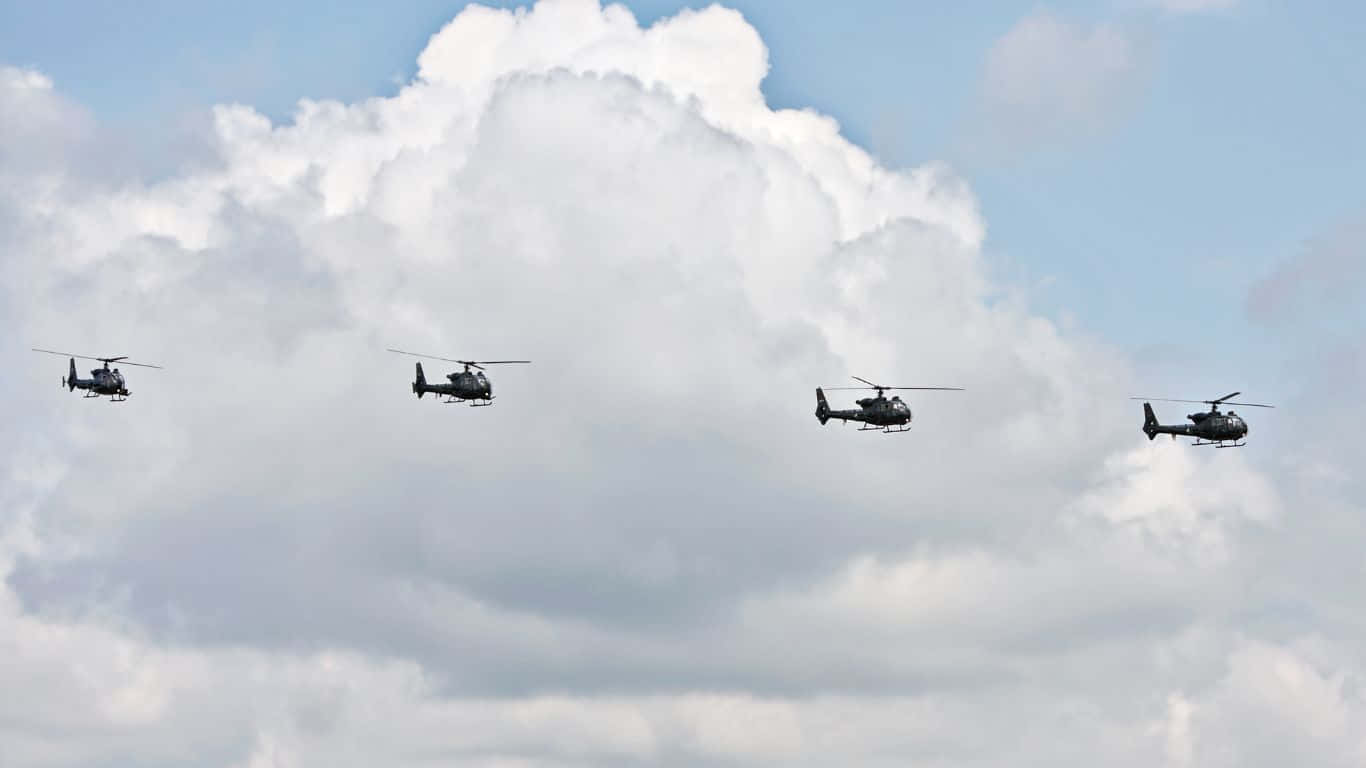 1366x768 Helicopters 桌布 壁紙 — 四架軍用直升機在蓬鬆的白雲和藍天背景下編隊飛行。
