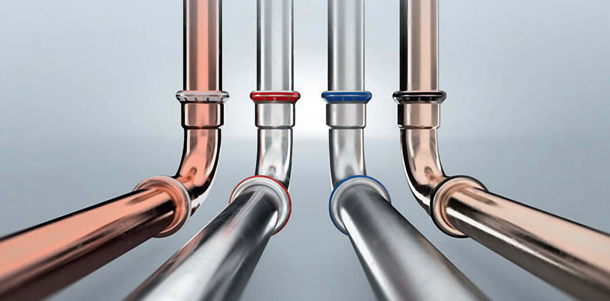 Plumbing 桌布 壁紙 — 四條金屬管帶有銅和鉻飾面，在柔和的灰色背景下向觀眾匯聚。