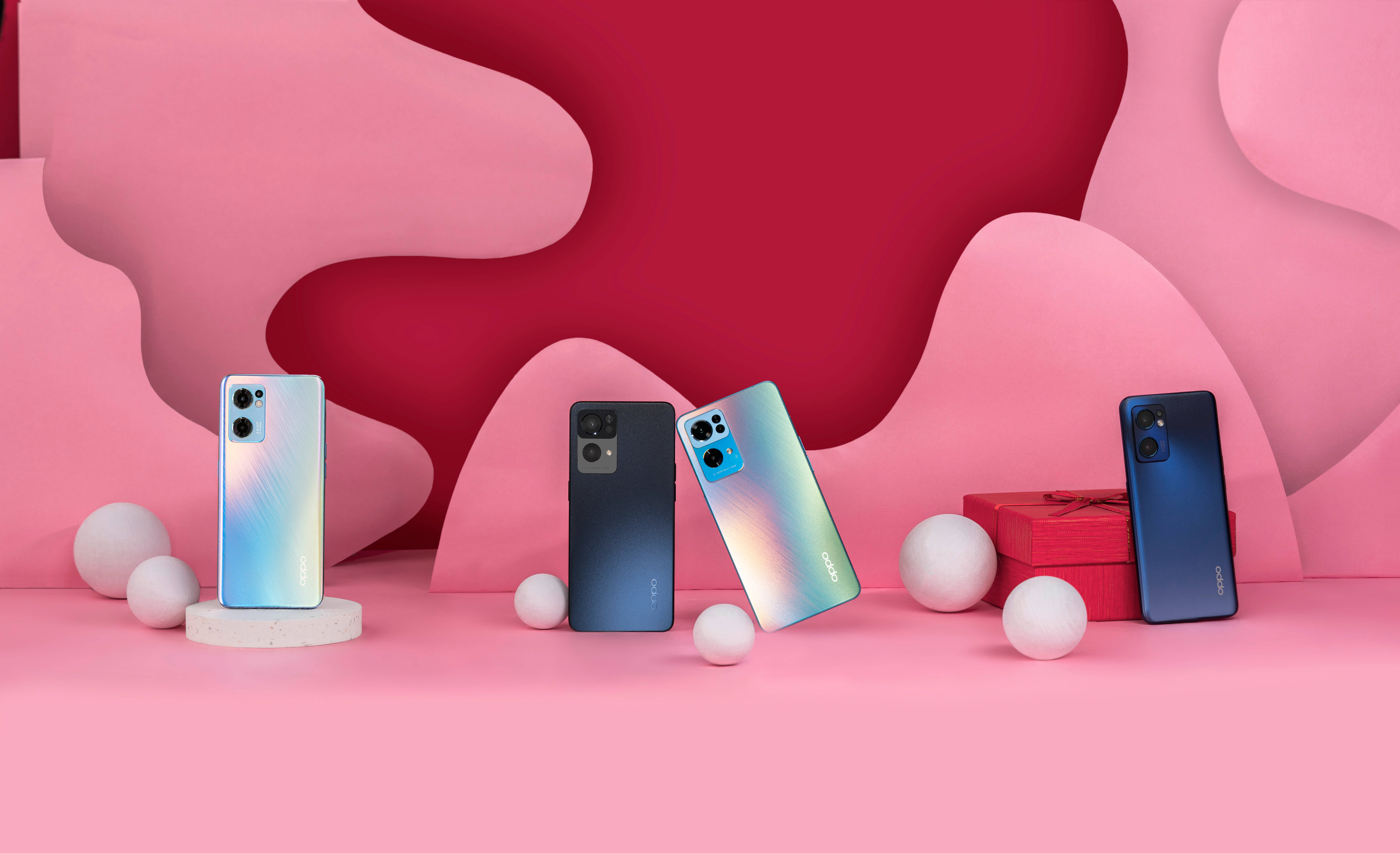 oppo 桌布 壁紙 — 四款色彩繽紛的智慧型手機展示在充滿活力的粉紅色抽象背景上，配有白色球體和一個紅色禮物盒。